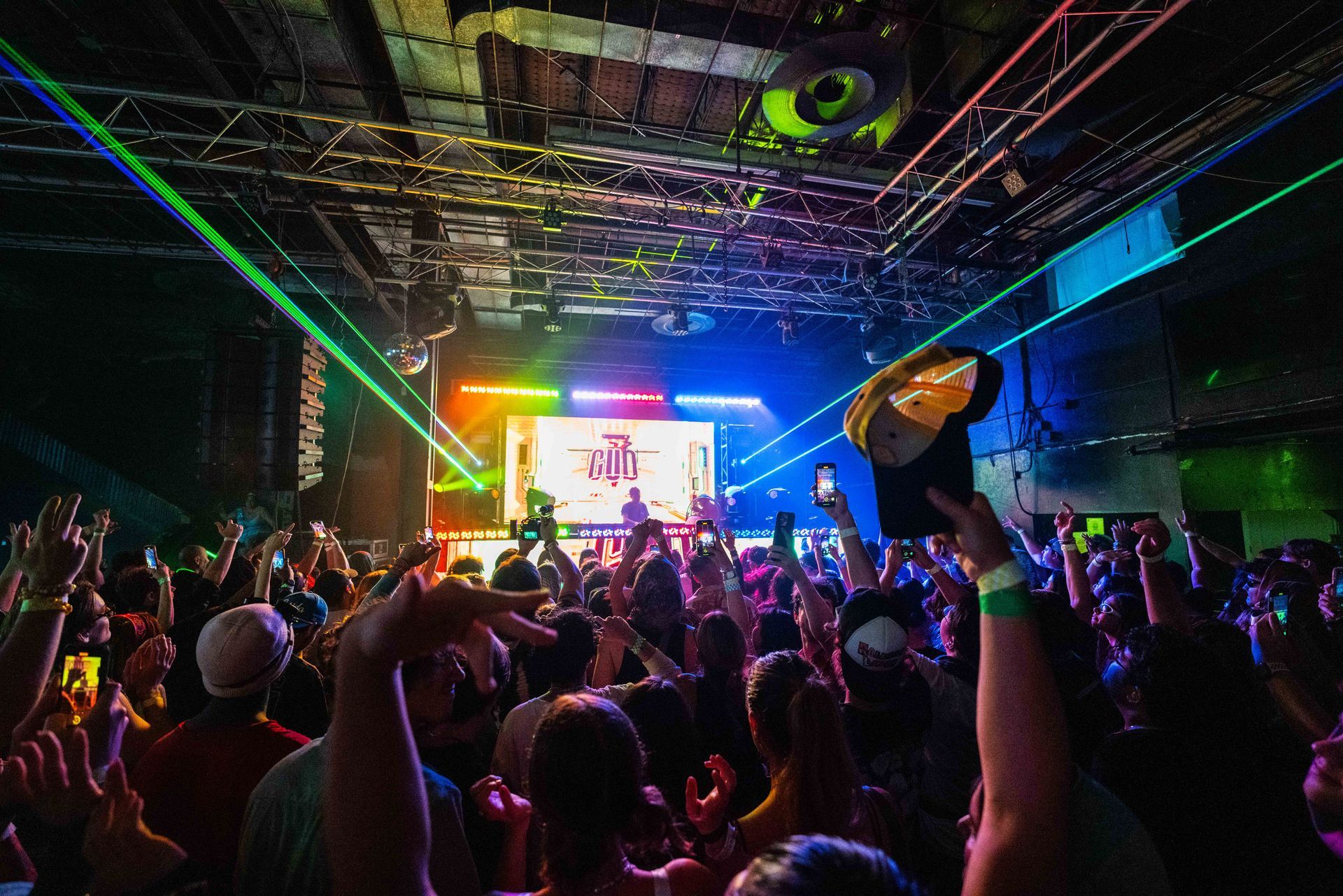A crowd of people are standing in front of a stage at a concert.
