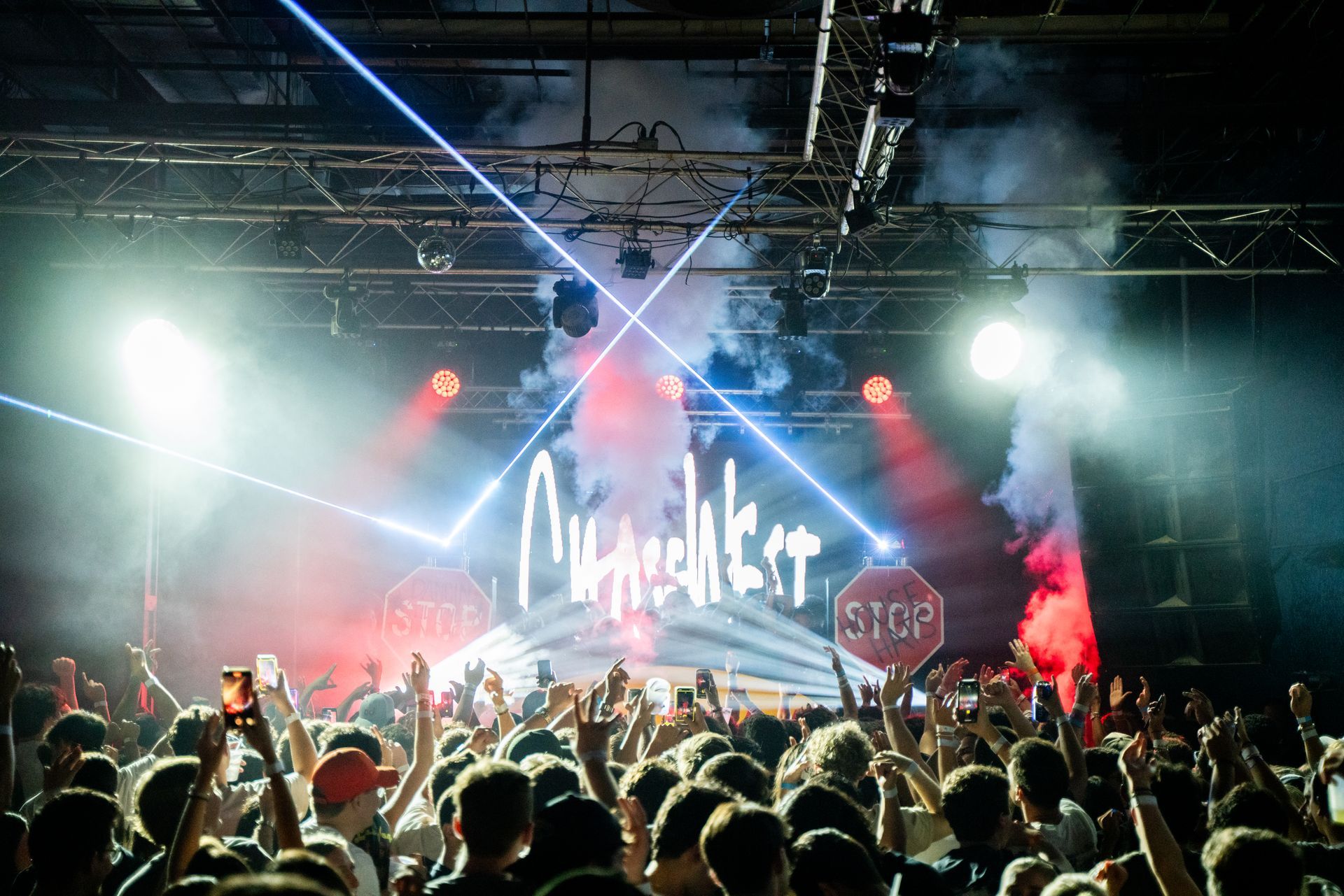A crowd of people are standing in front of a stage at a concert.