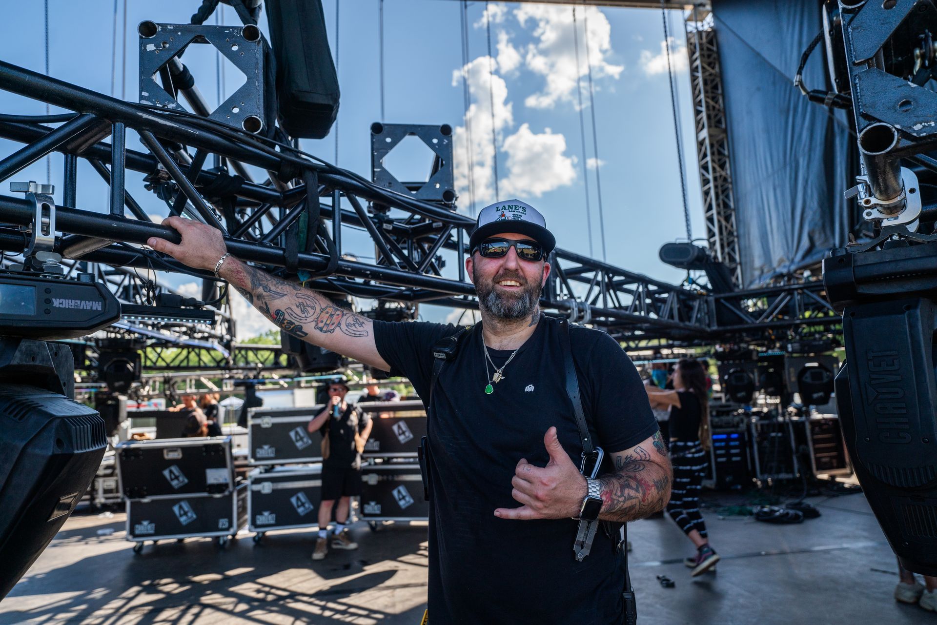 A man is standing in front of a stage giving a thumbs up.