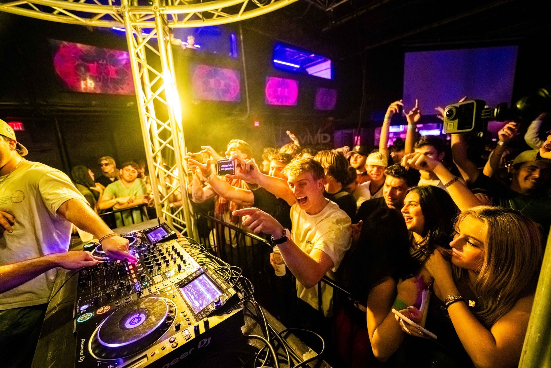 A dj is playing music to a crowd of people at a party.