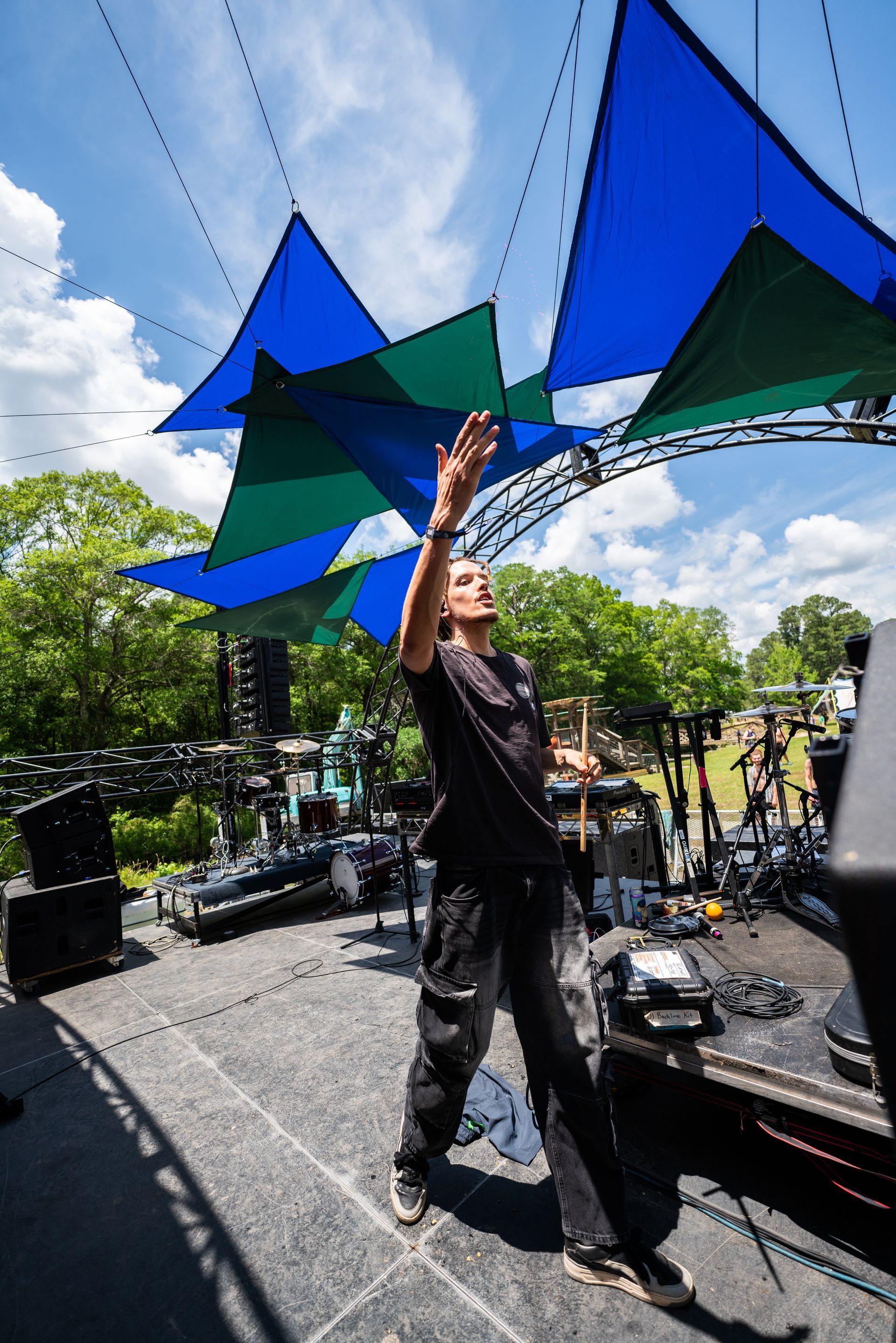 A man is standing on a stage with his hands in the air.