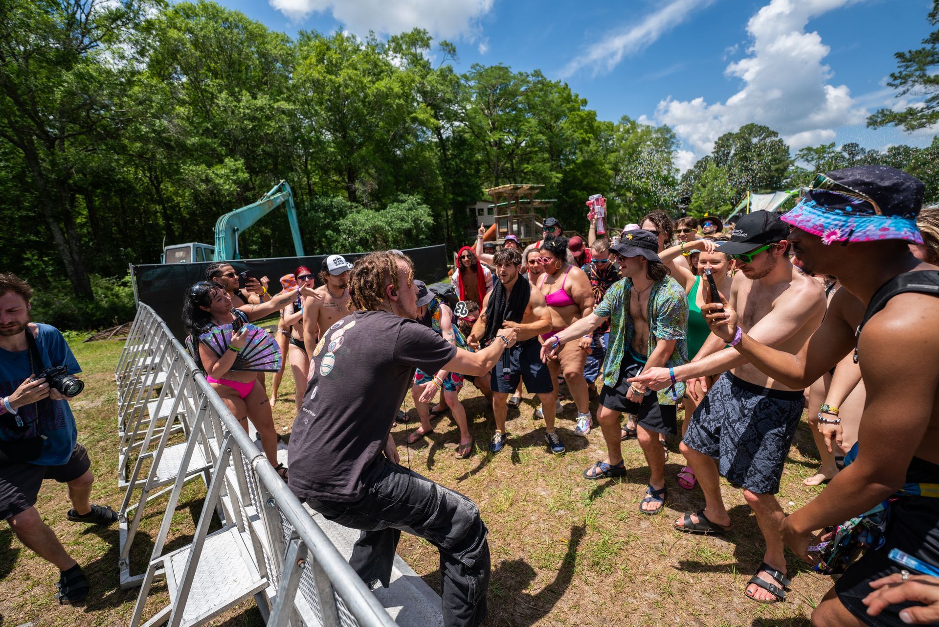 A man is standing in front of a crowd of people at a music festival.