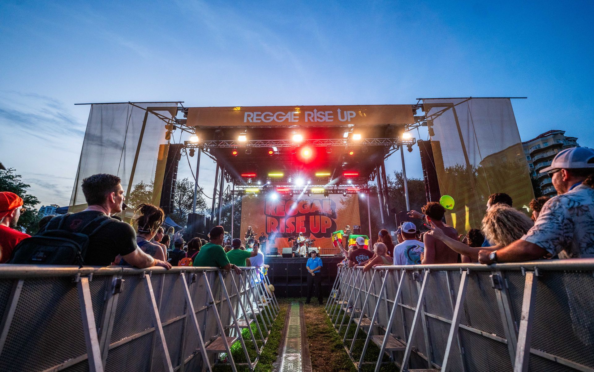 A group of people are sitting in front of a stage at a concert.