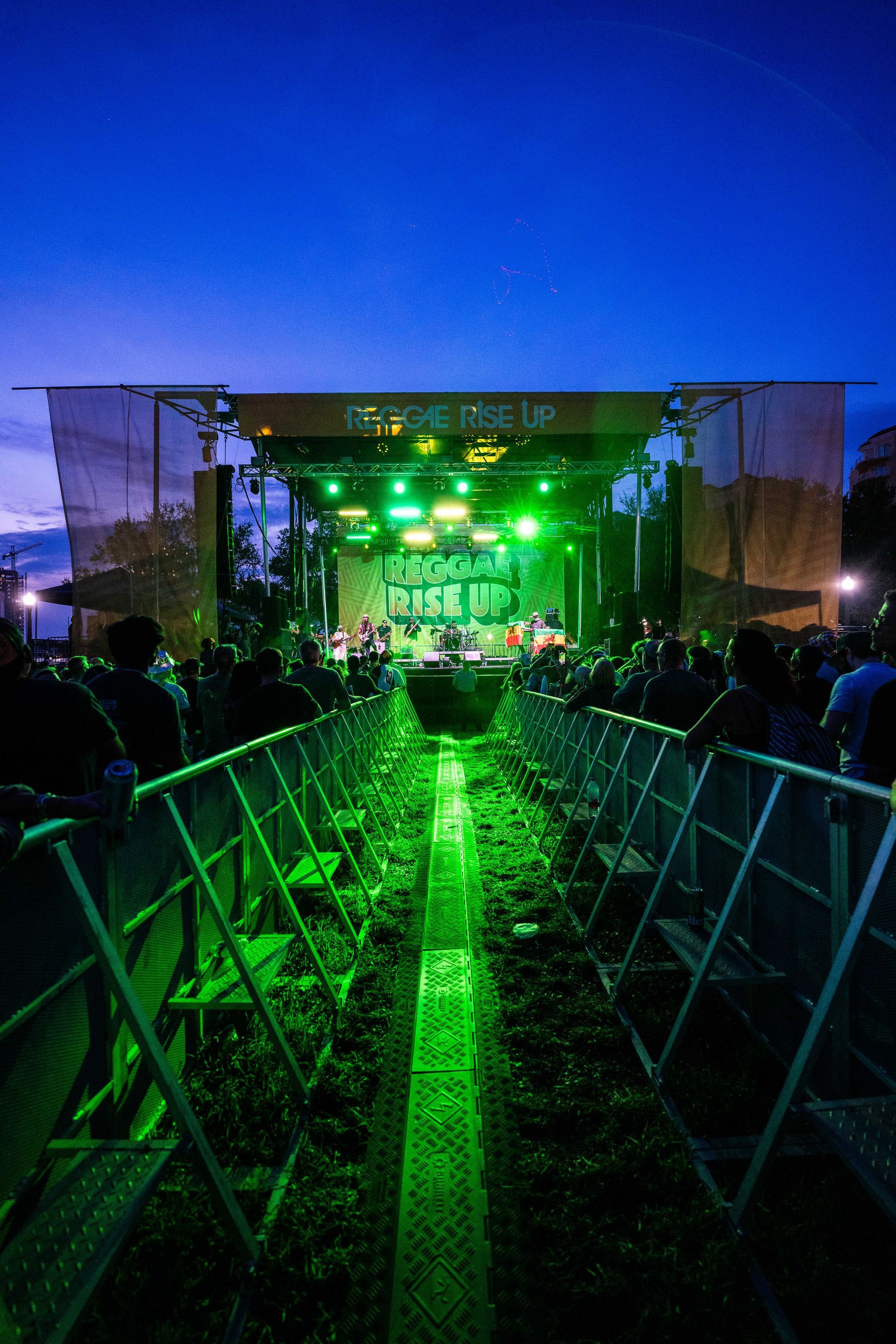 A group of people are standing in front of a stage at a concert.