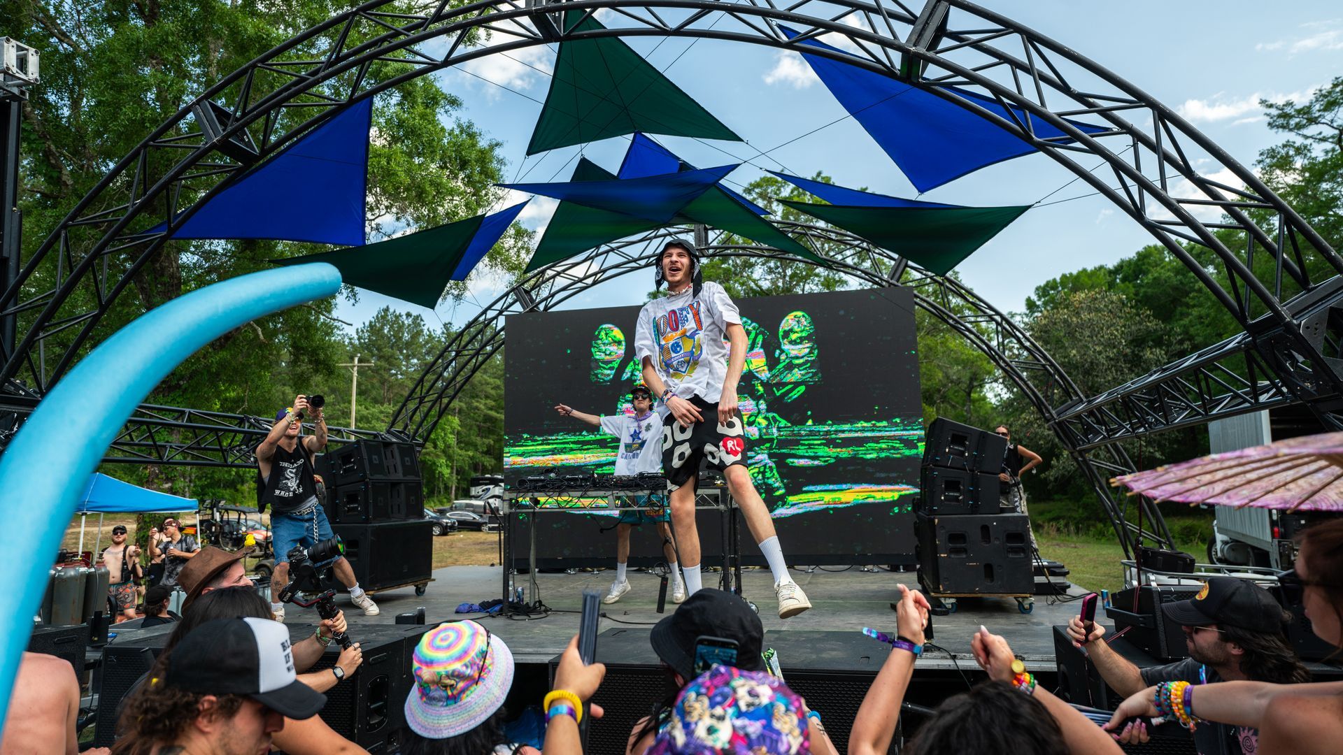 A man is standing on a stage playing a guitar in front of a crowd.