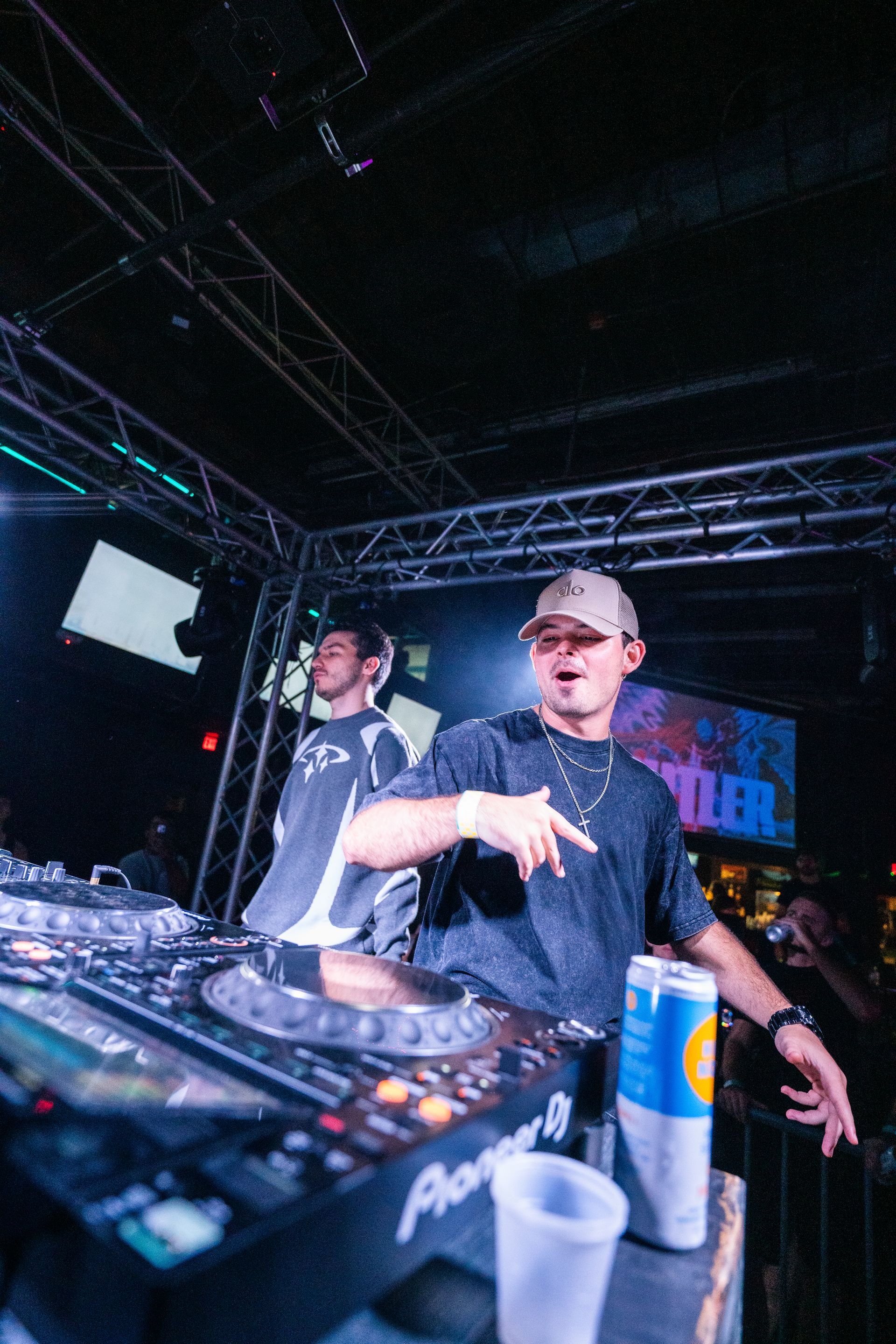 Two men are playing music on a stage in a club.