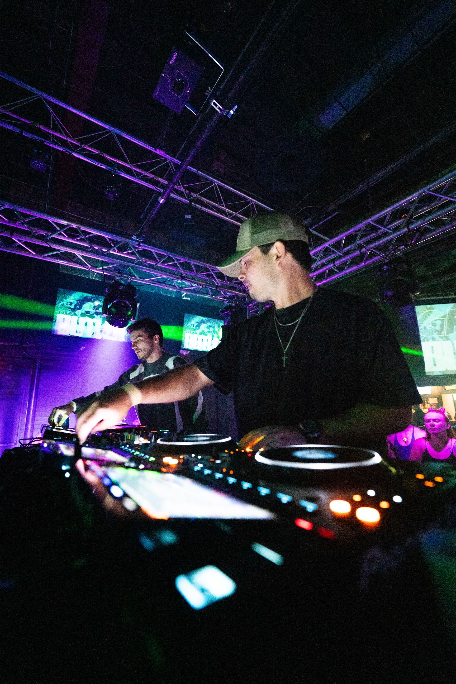 A man is playing a dj set in a dark room.