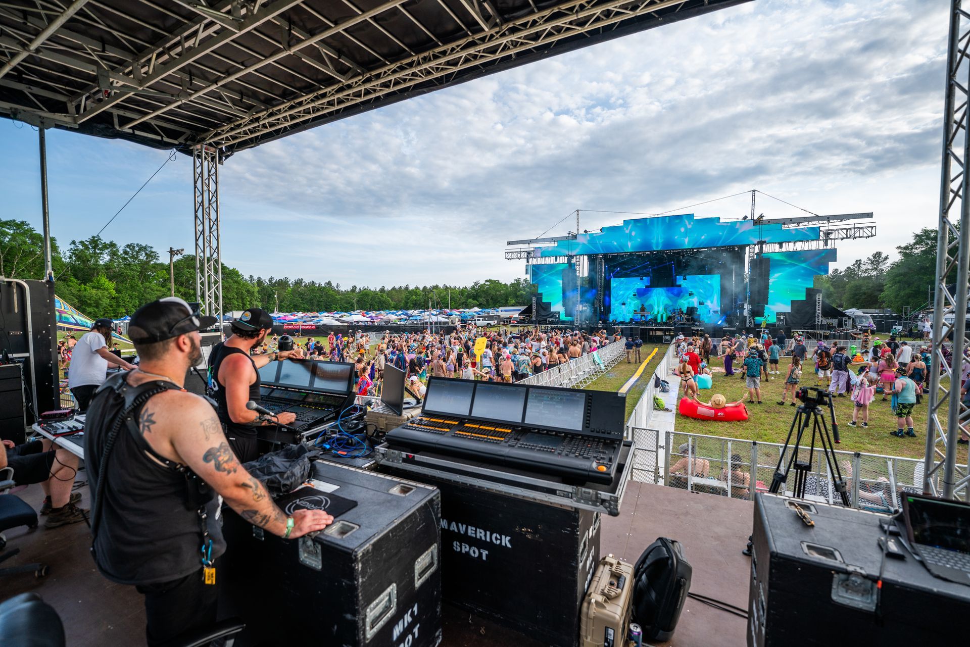 A group of men are standing on a stage at a music festival.