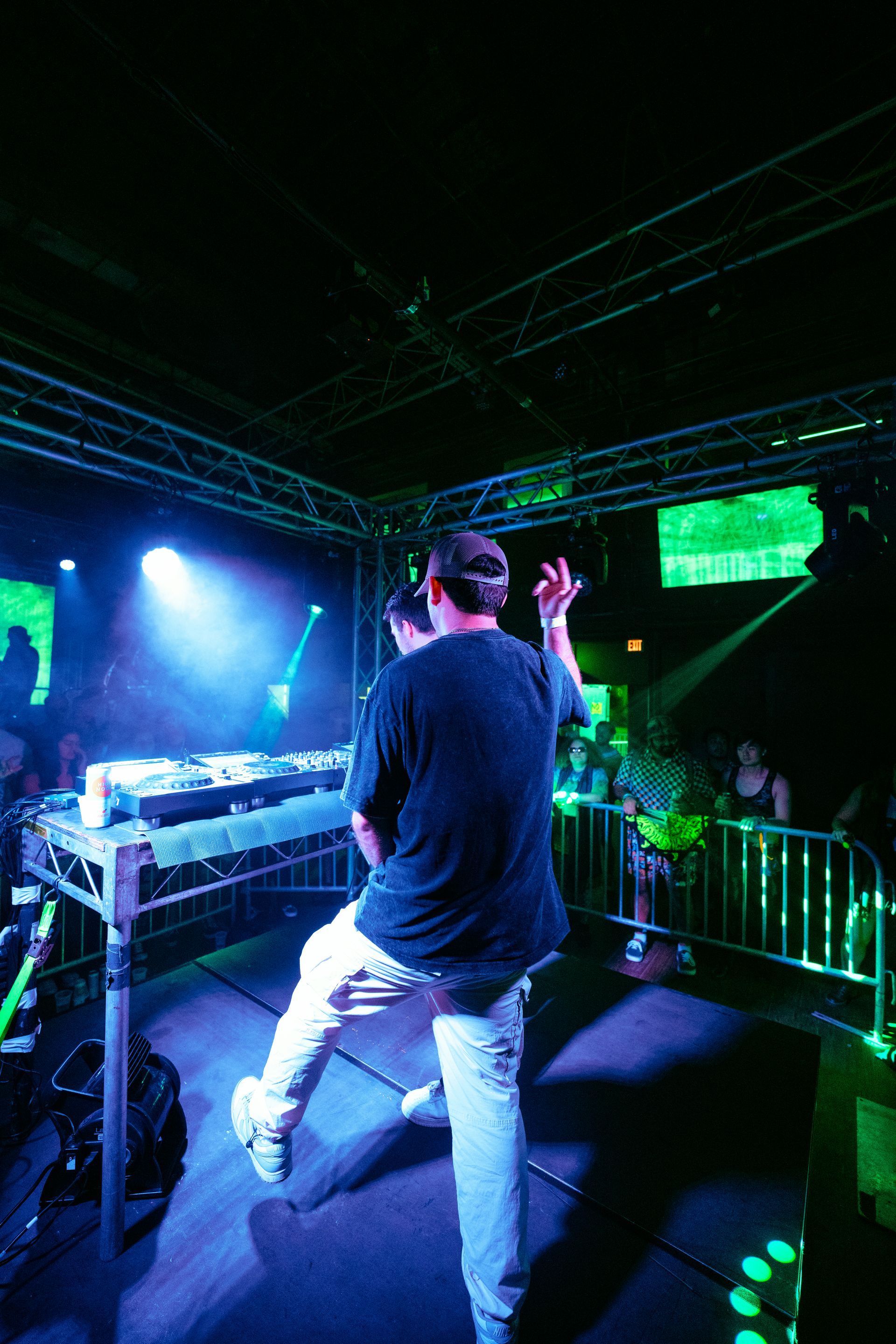A man is standing on a stage in front of a crowd in a dark room.