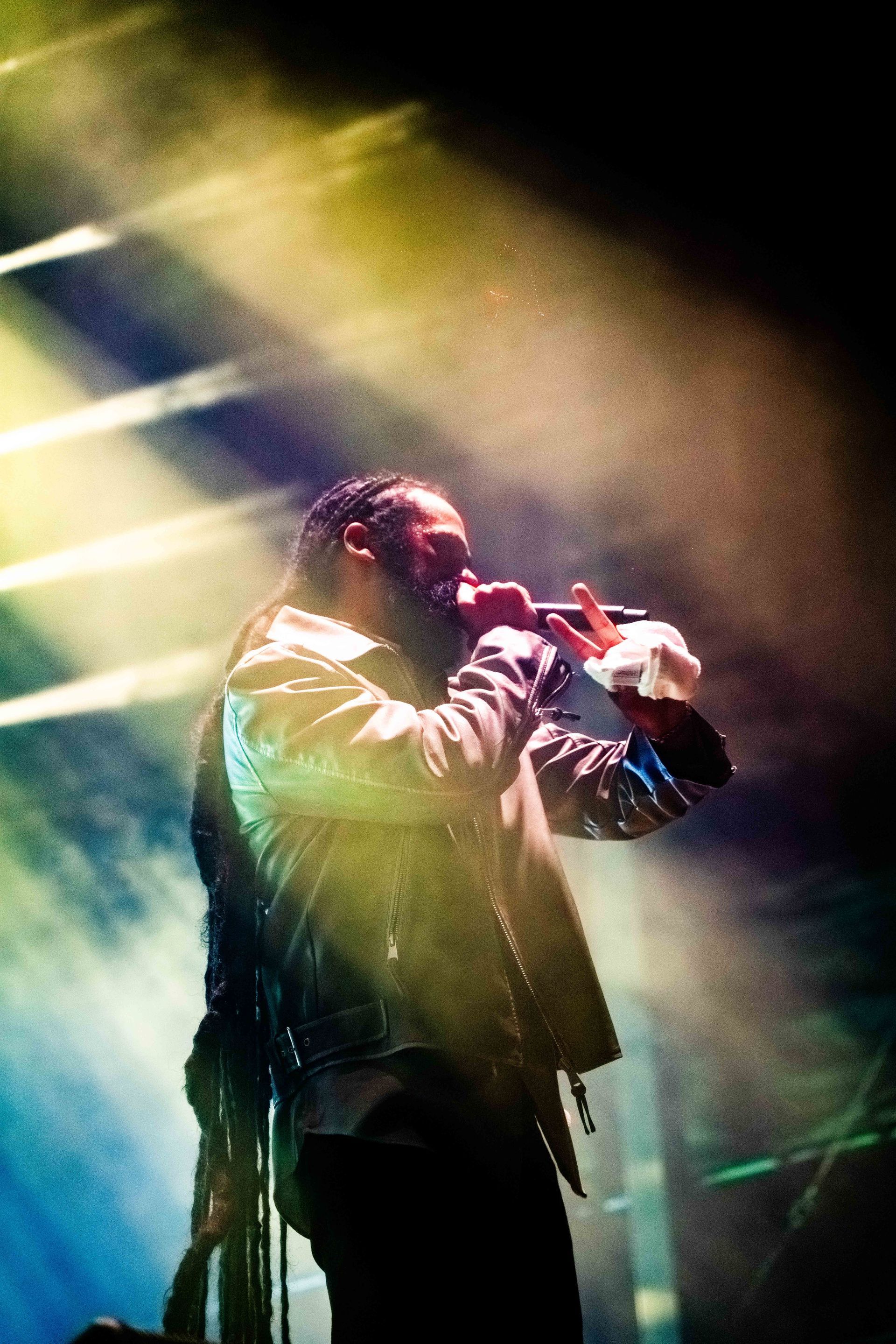 A man is singing into a microphone on a stage.