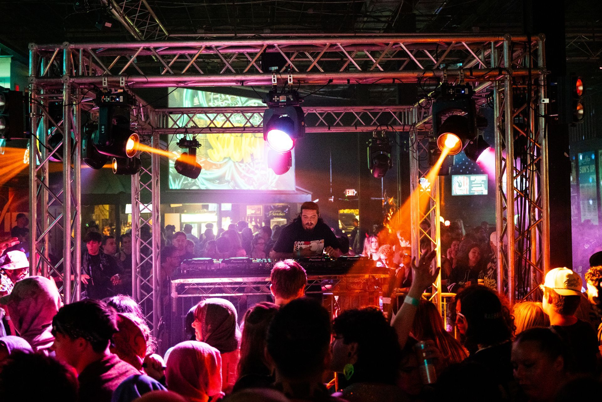 A man is playing a dj set in front of a crowd of people