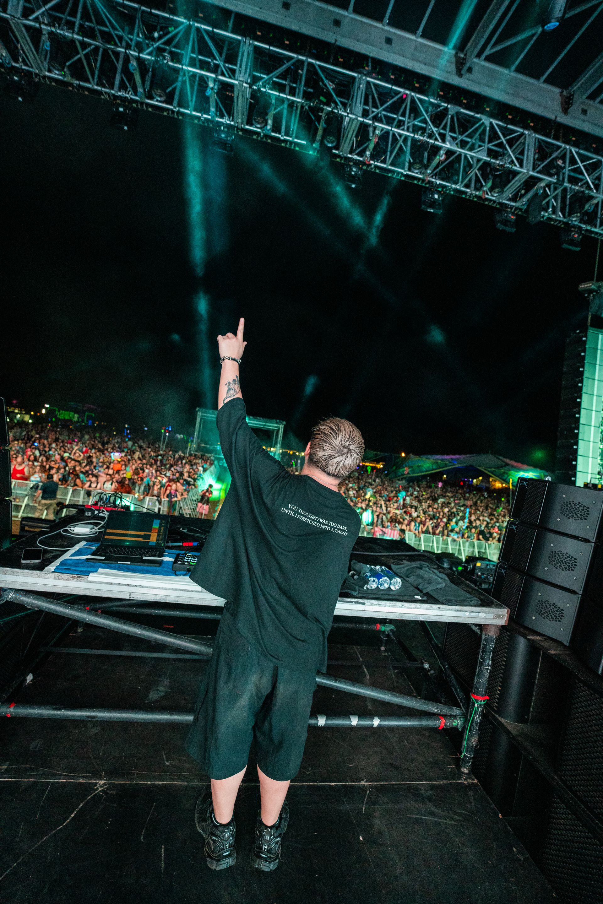 A man is standing on a stage with his arms in the air.