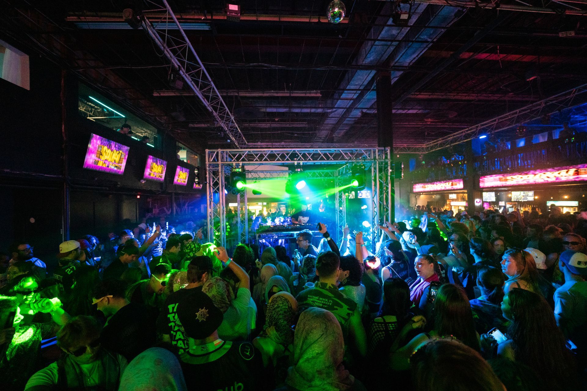 A large crowd of people are dancing in a club.