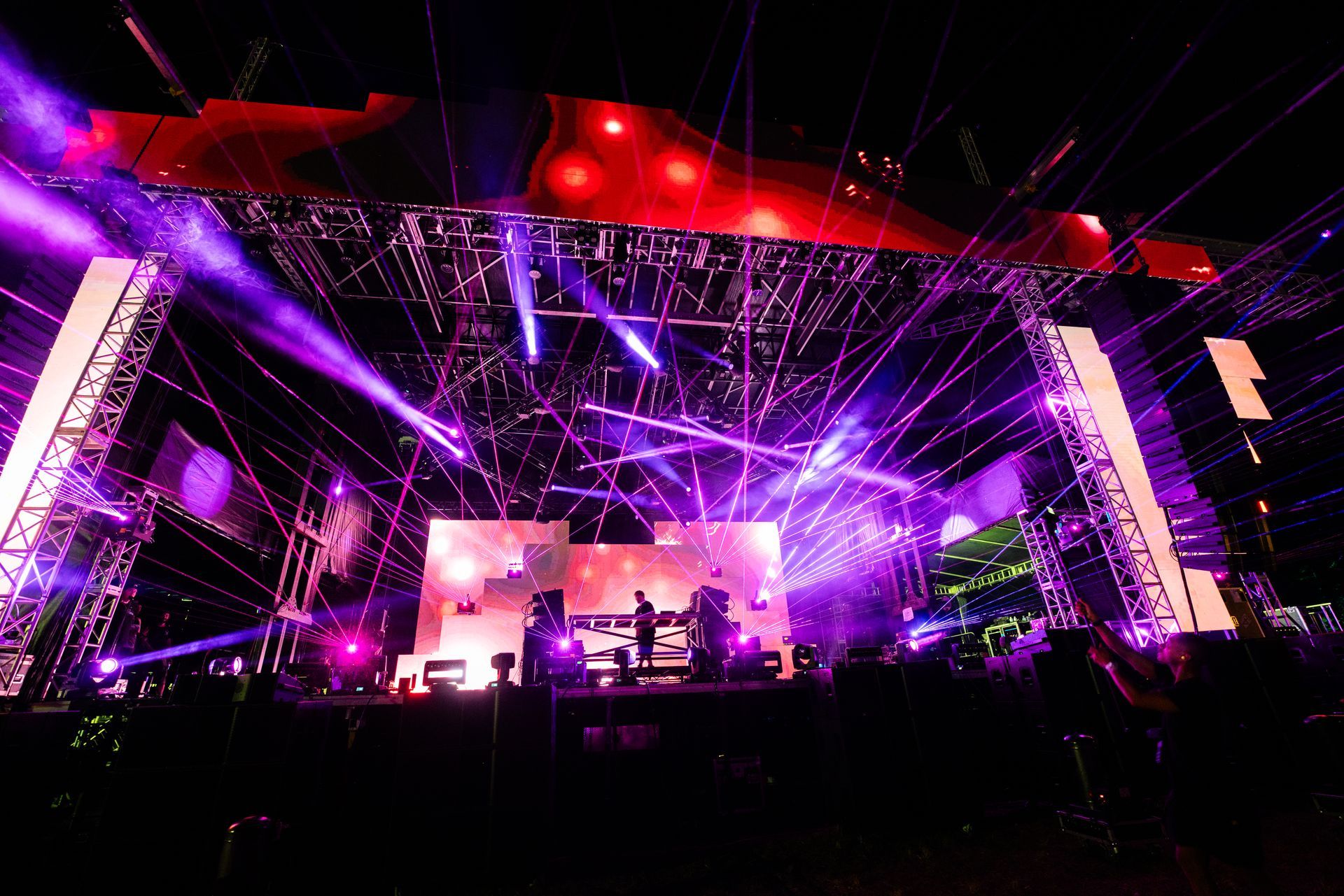 A group of people are standing on a stage with purple lights