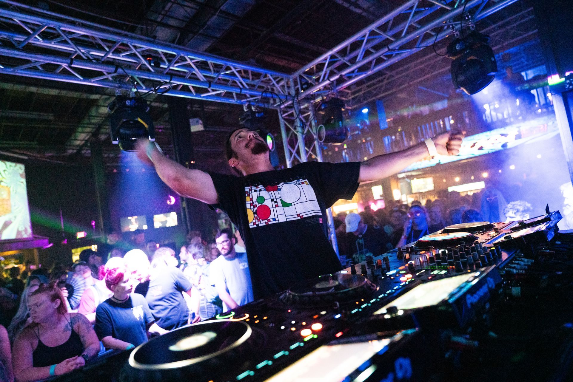 A dj is playing music in front of a crowd at a party.