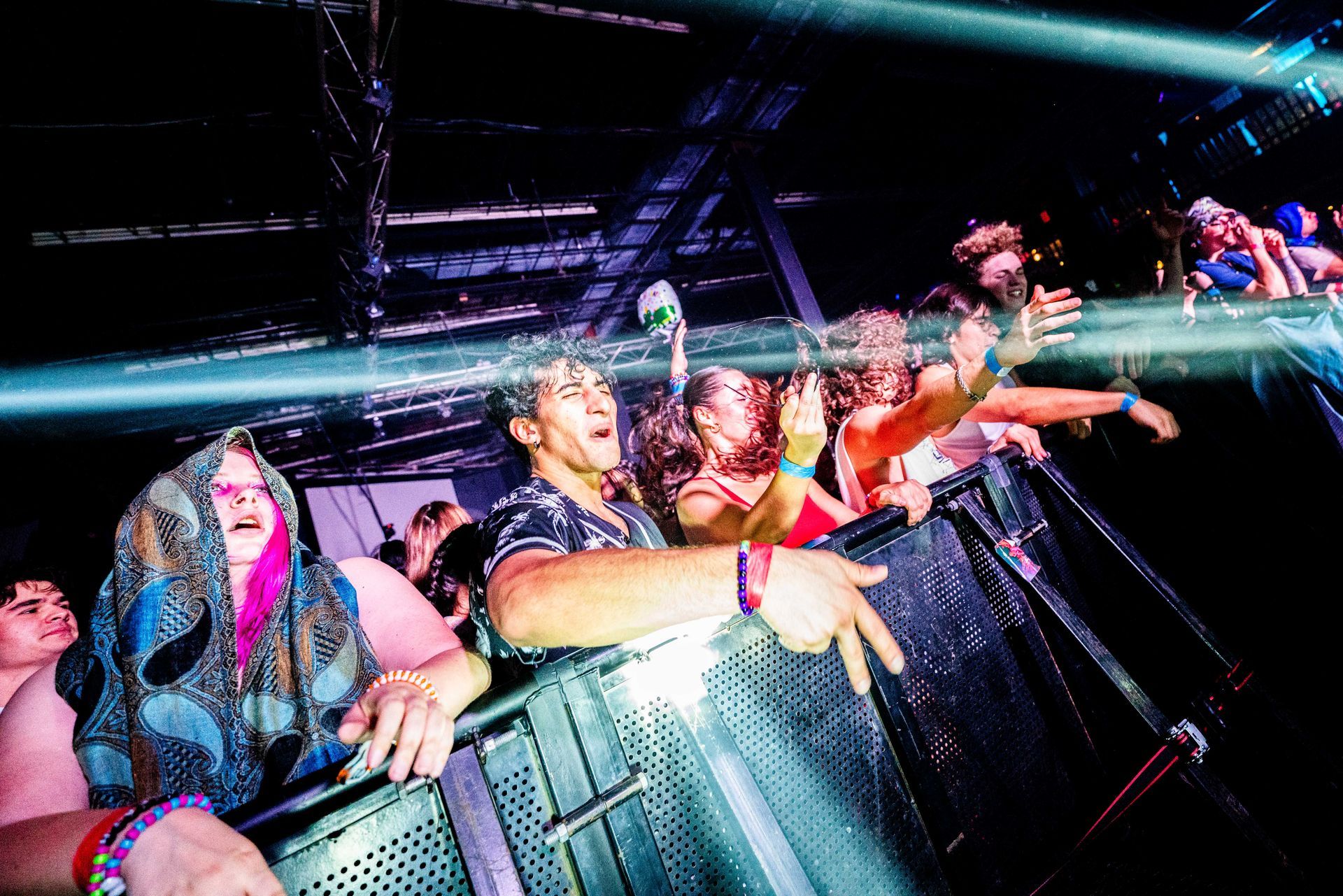 A crowd of people are standing in front of a stage at a concert.