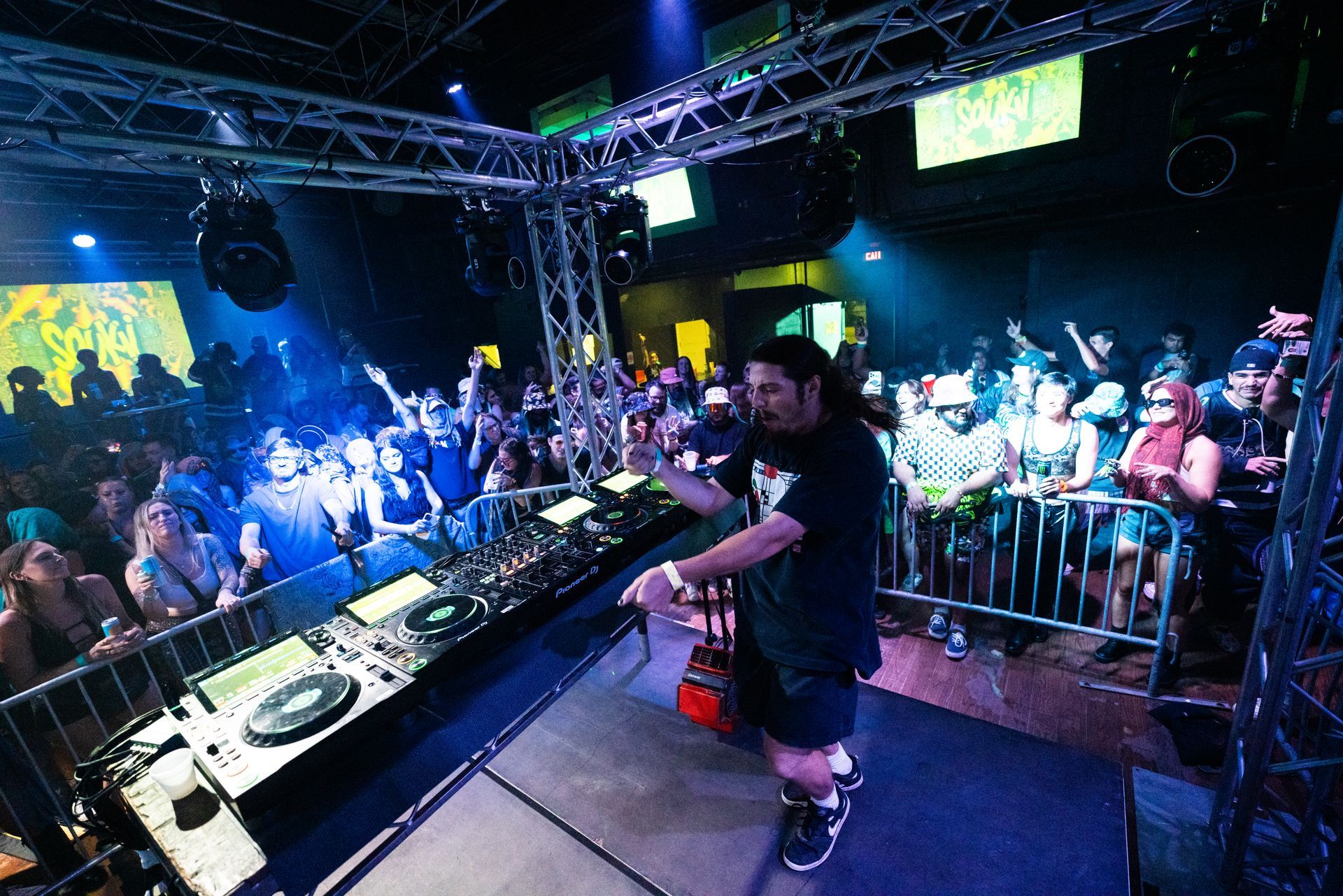A man is kneeling on a stage in front of a crowd of people.