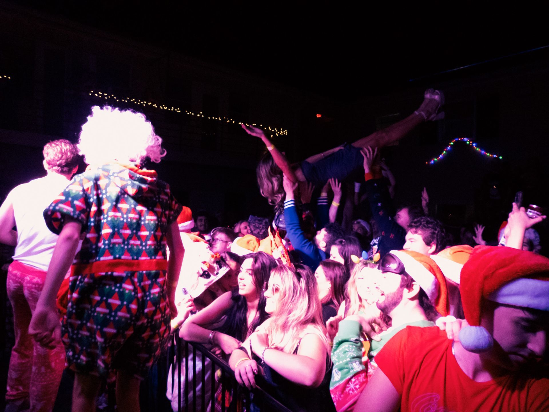 A man in a santa hat stands in front of a crowd of people