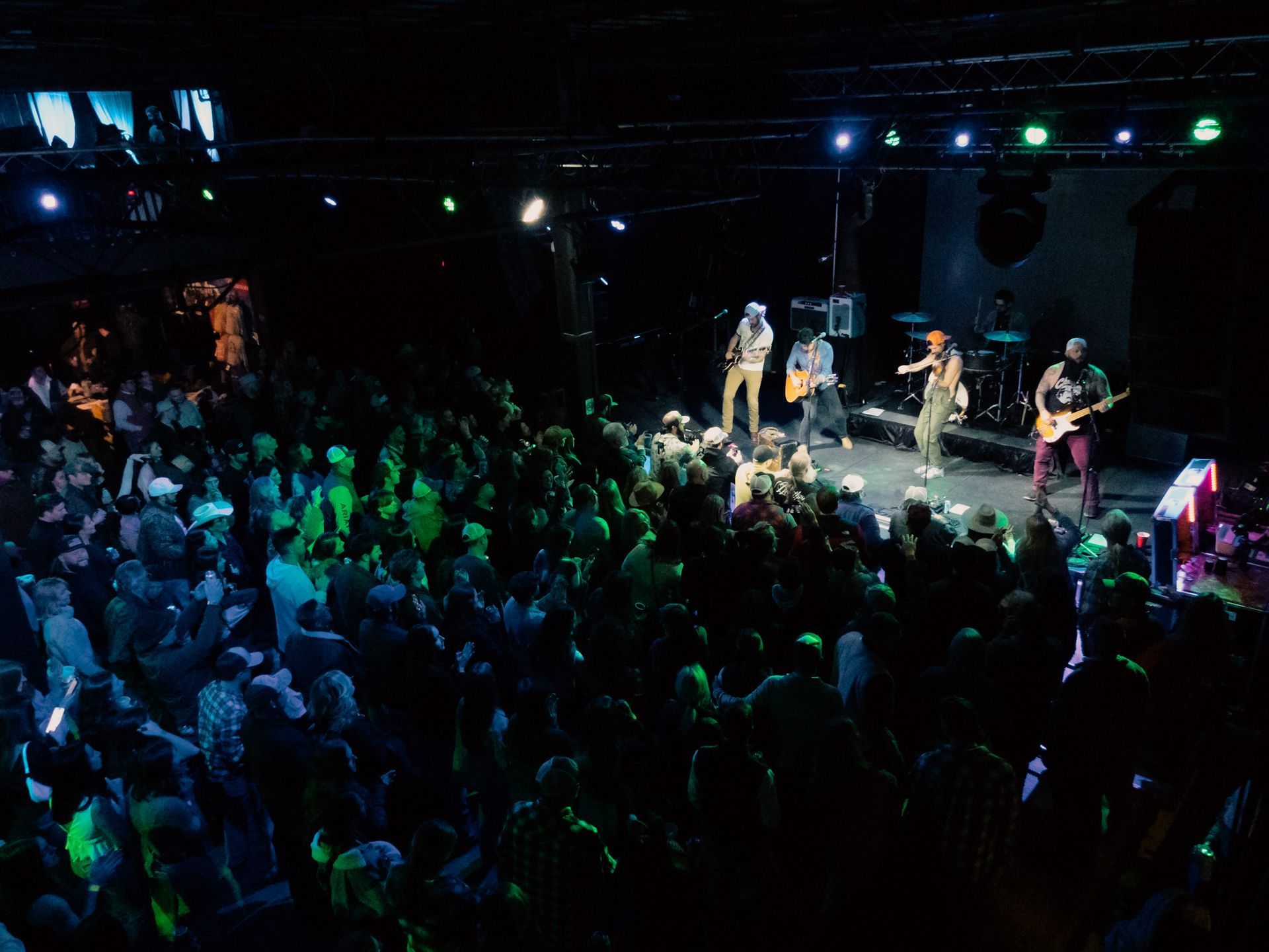 A group of people are playing instruments on a stage in front of a crowd.