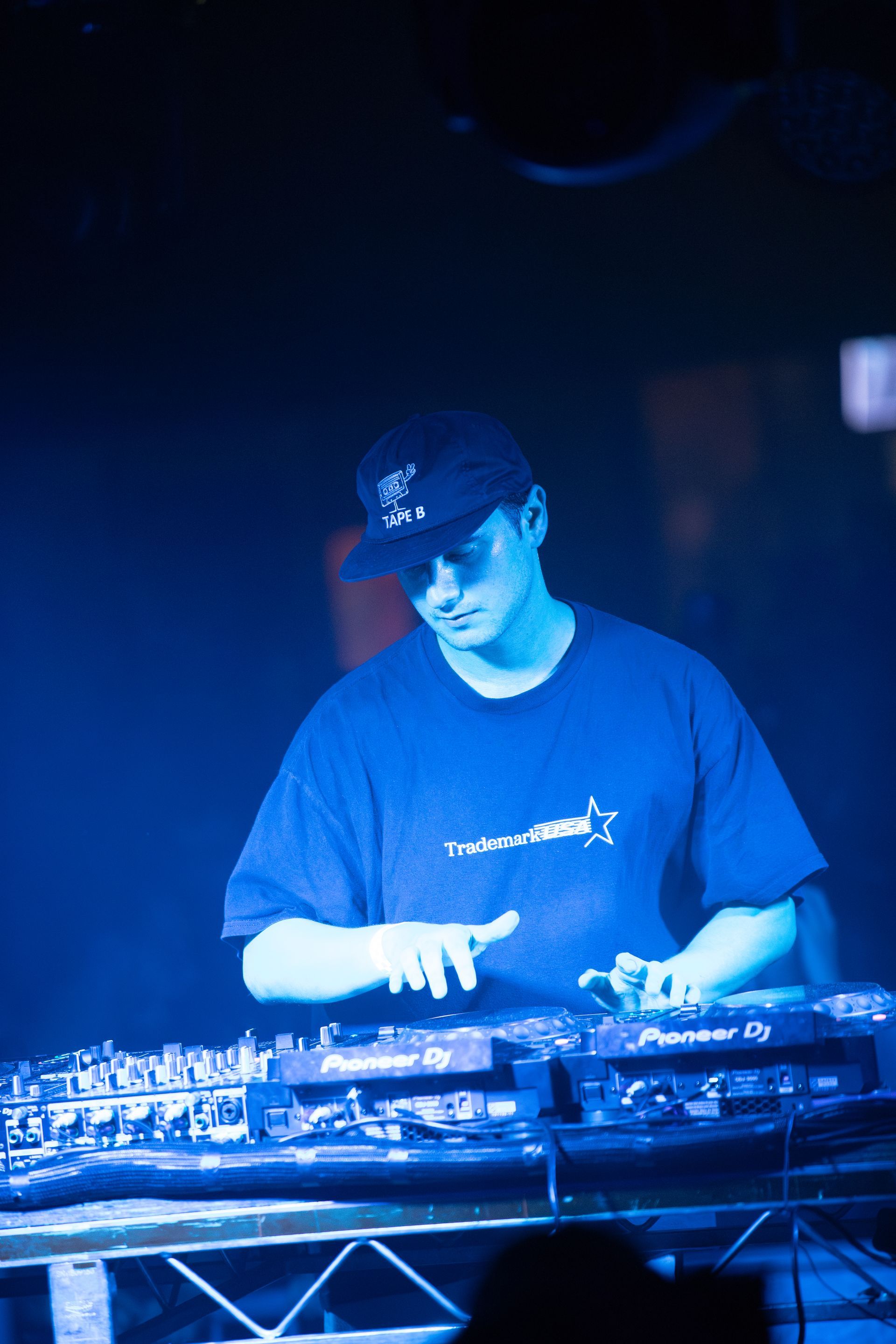 A man in a blue shirt is playing a dj set