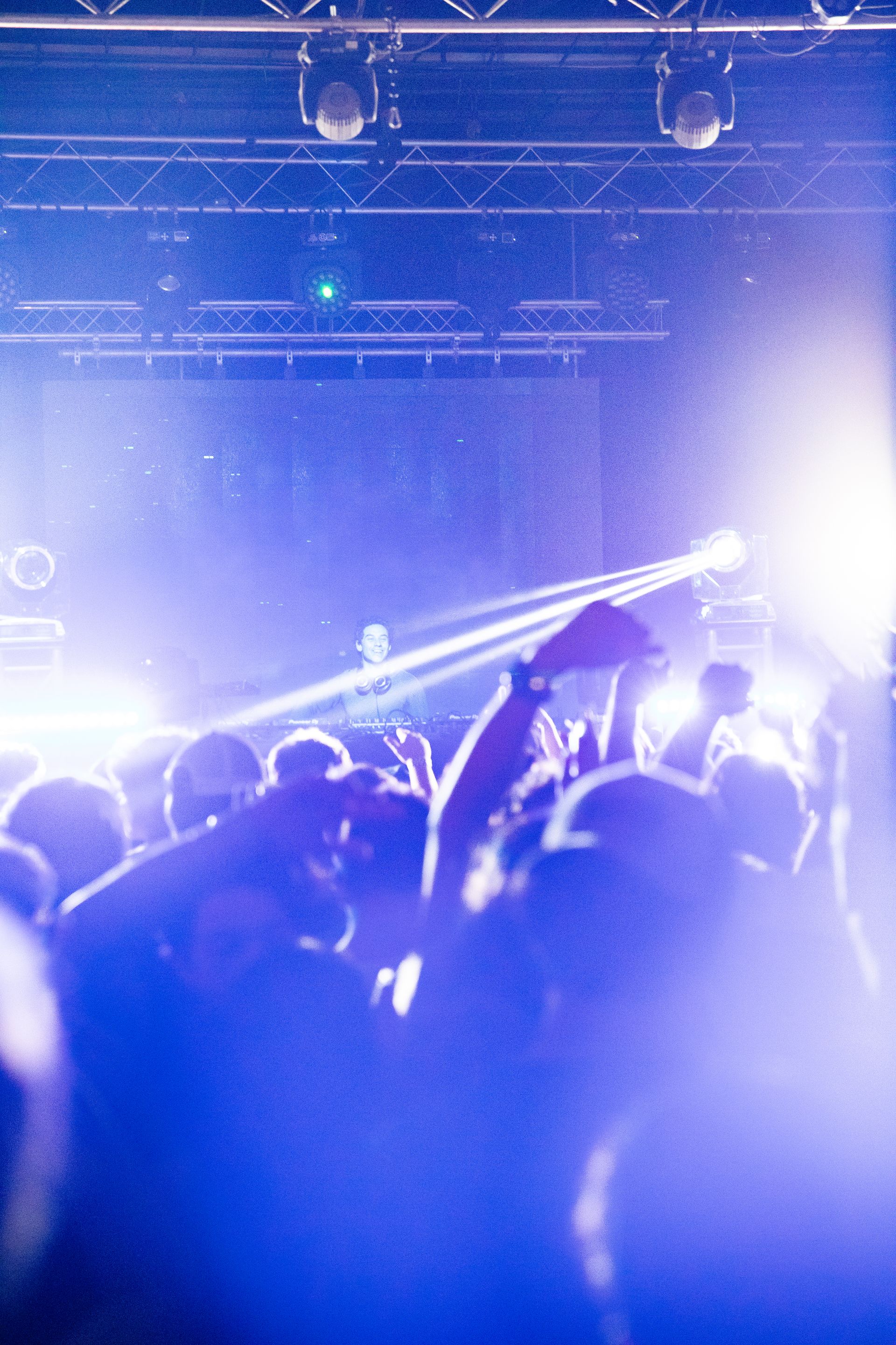 A crowd of people are standing in front of a stage at a concert.
