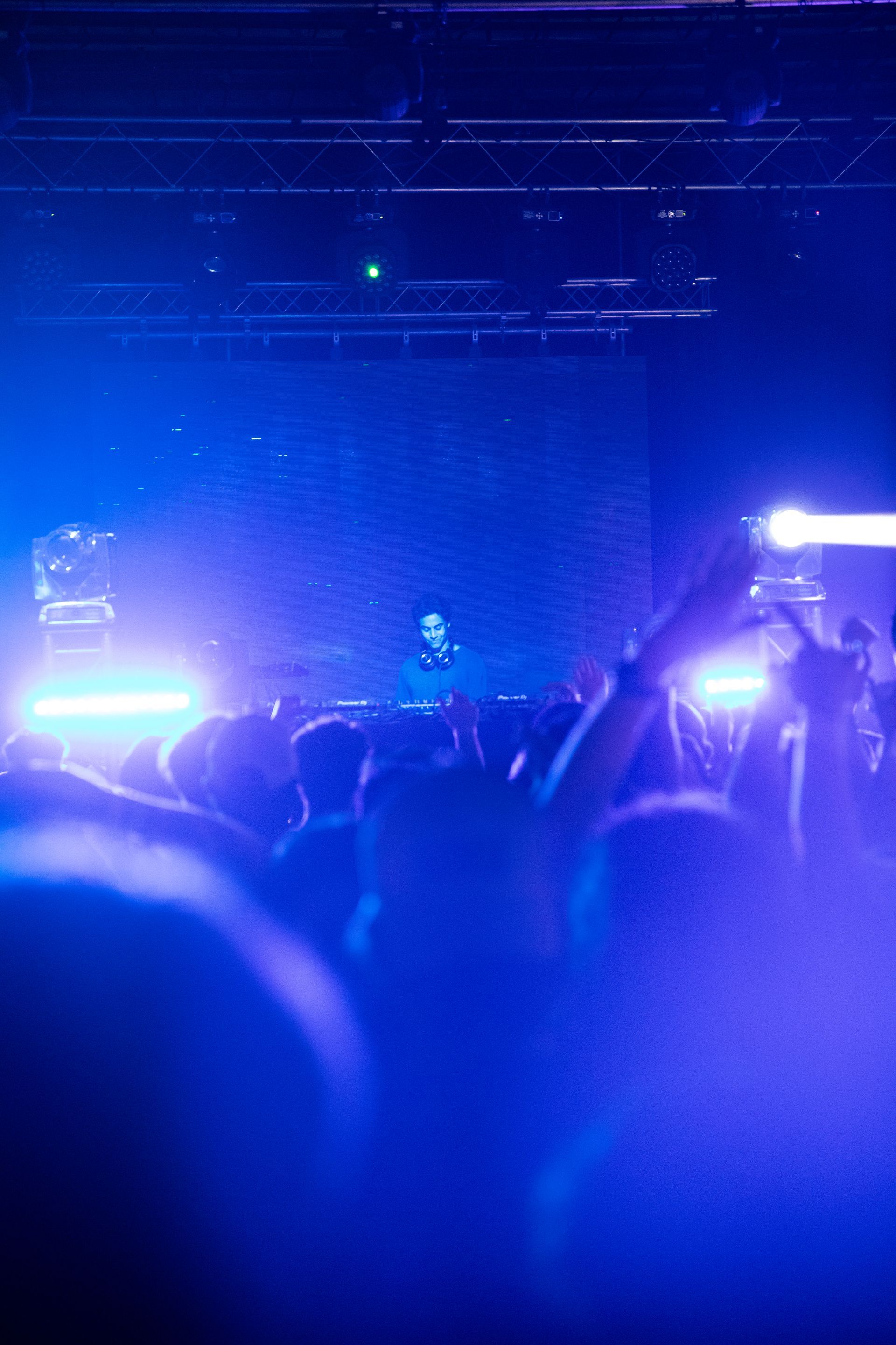 A crowd of people are standing in front of a stage at a concert.