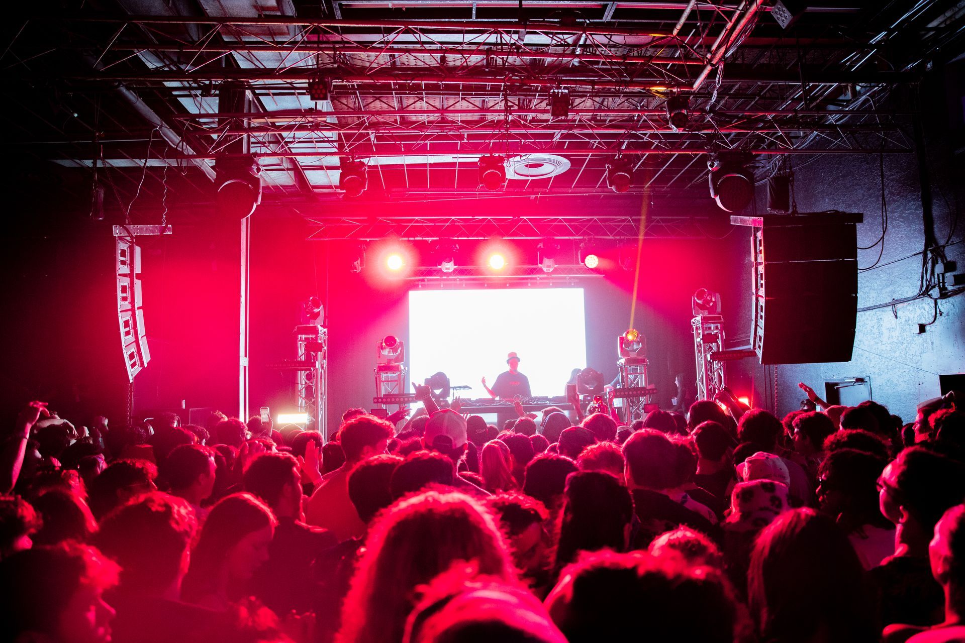 A crowd of people at a concert with red lights