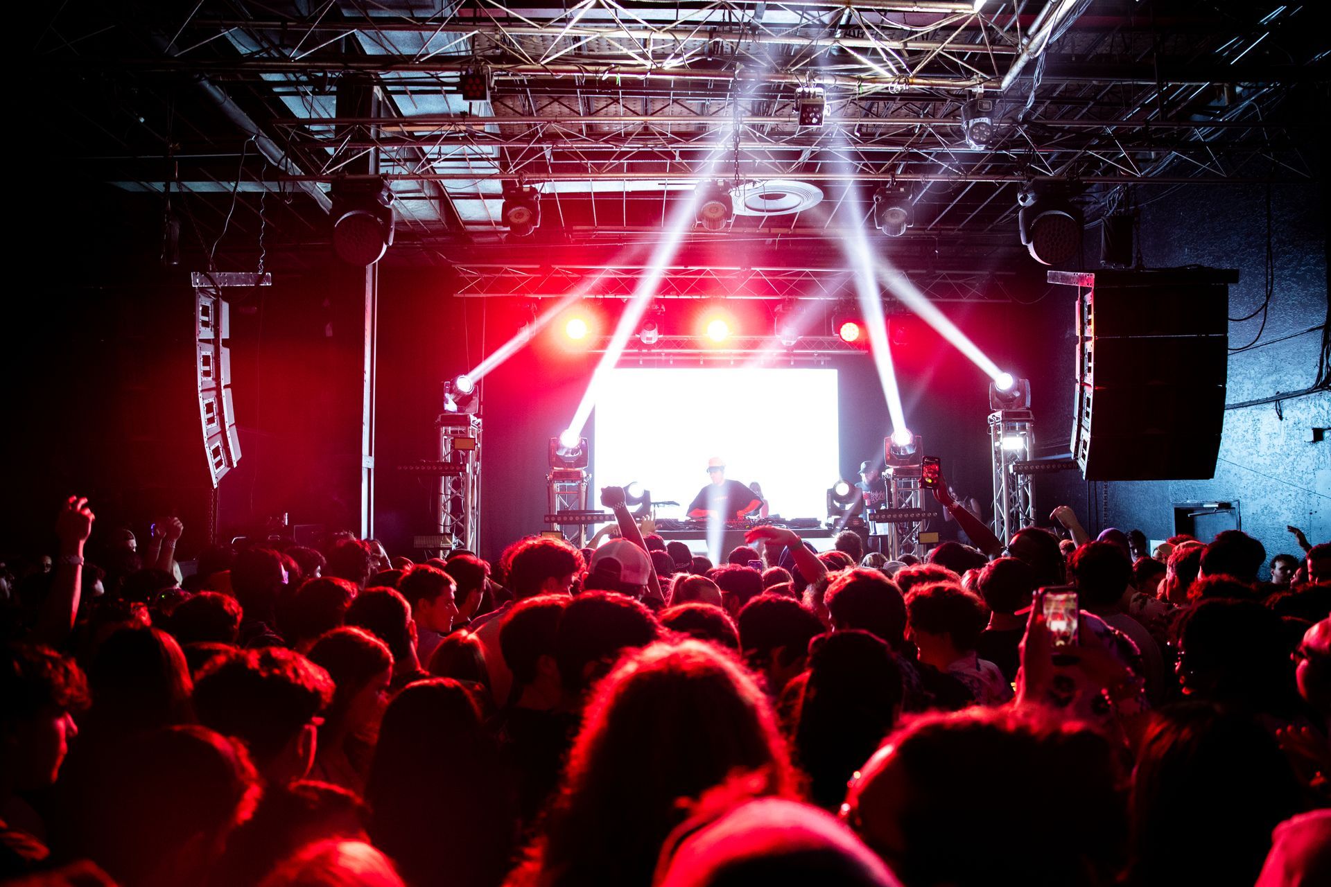 A crowd of people are standing in front of a stage at a concert.