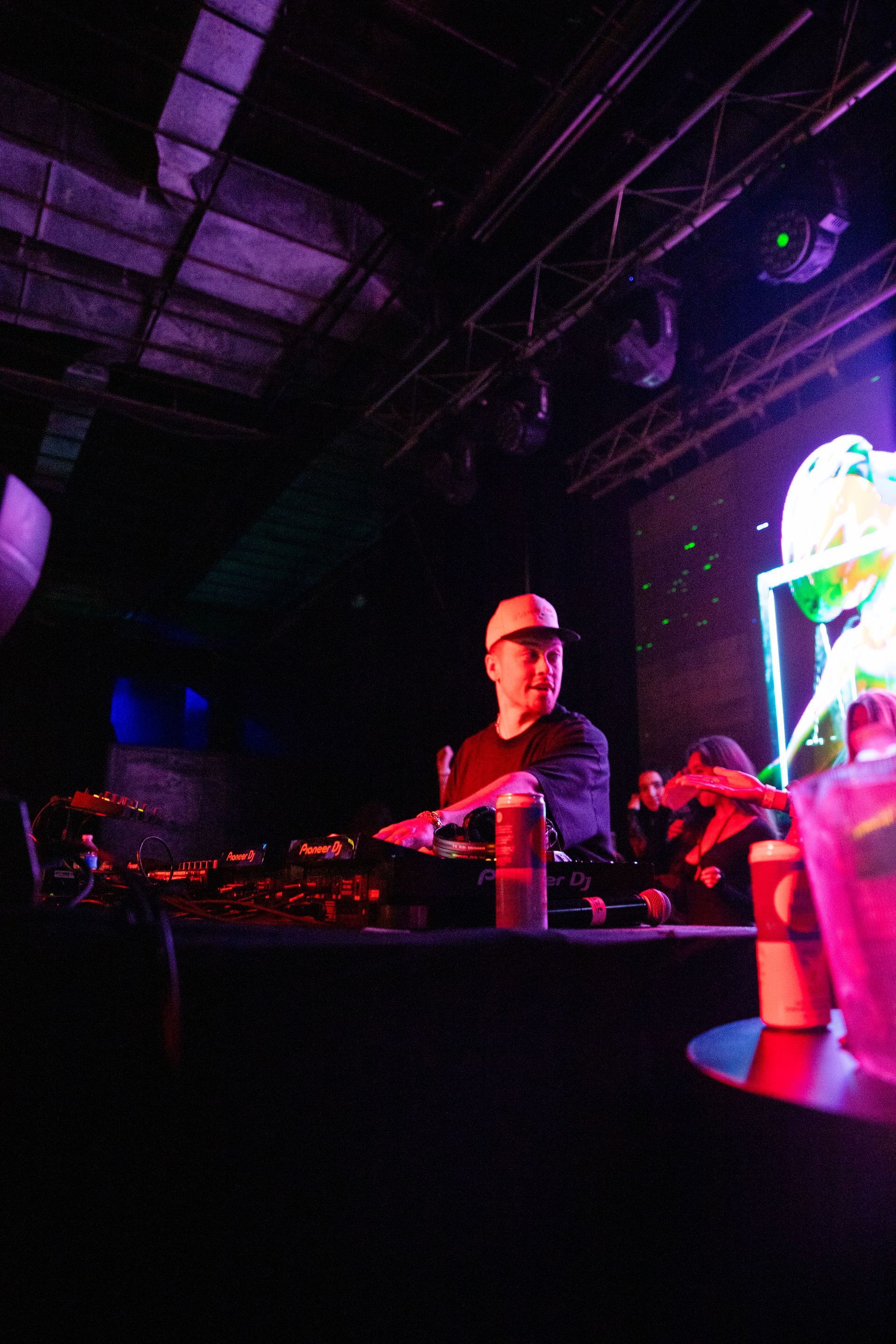 A man in a hard hat is playing drums in a dark room.
