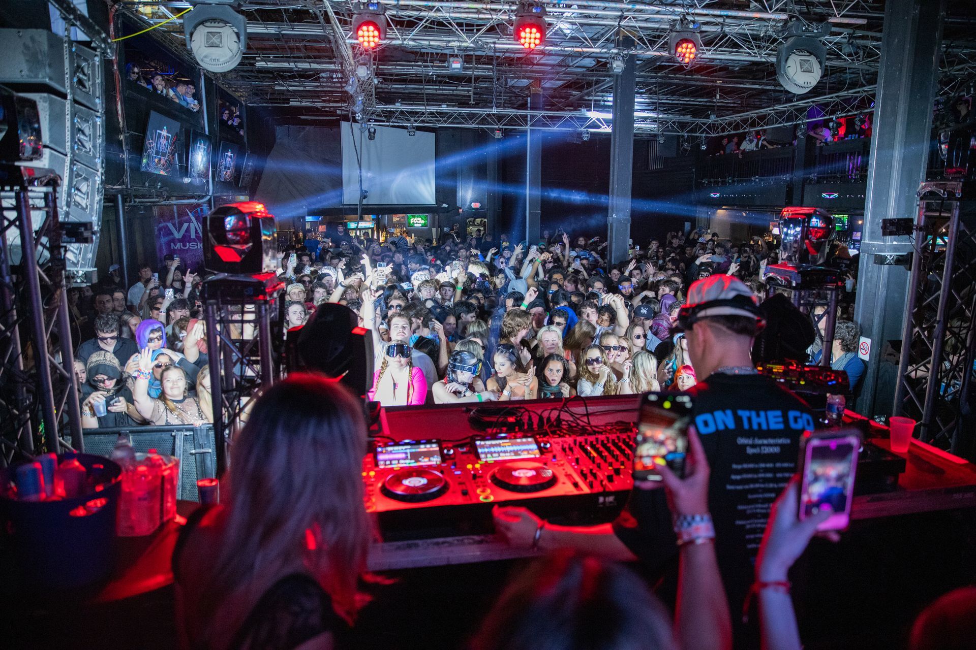 A dj is playing music in front of a crowd at a party.