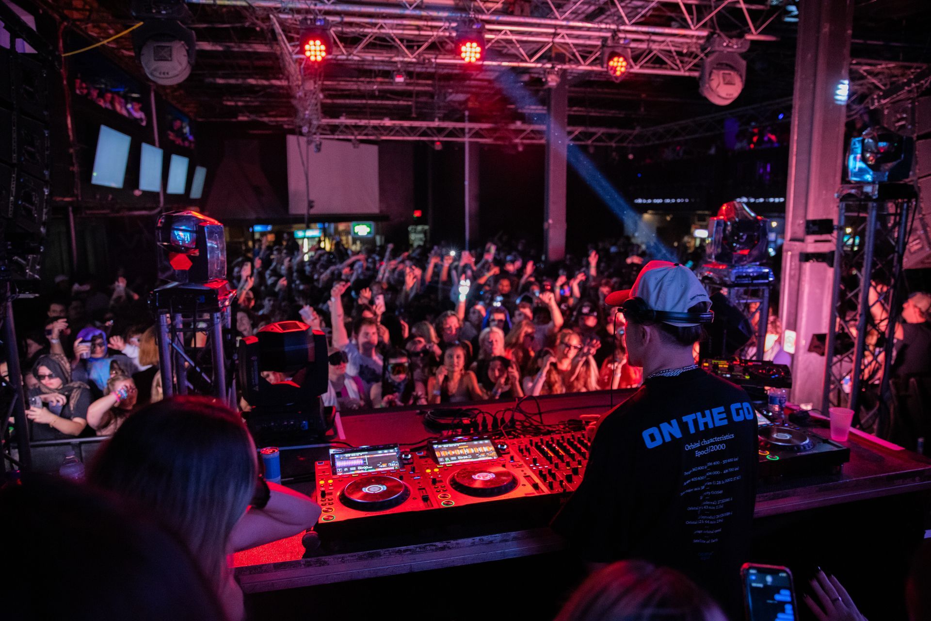 A dj is playing music in front of a crowd at a party.