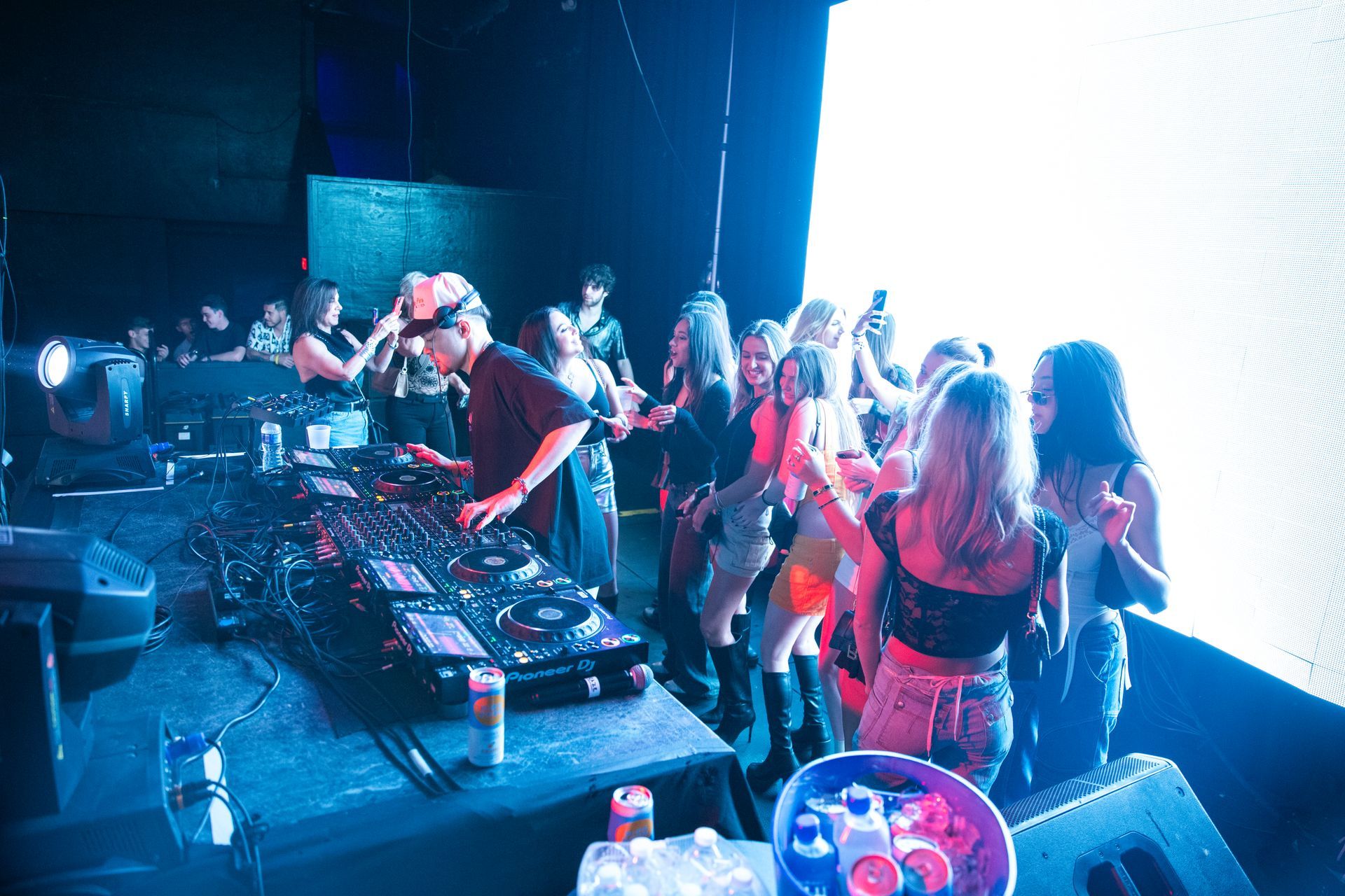 A dj is playing music in front of a crowd of people at a party.