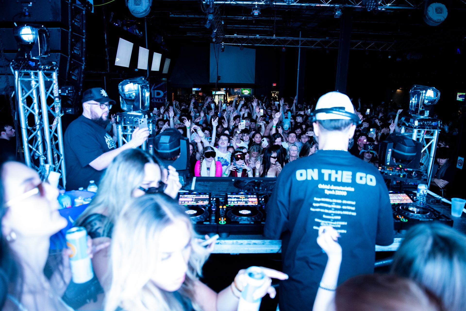 A man wearing a shirt that says on the do is standing in front of a crowd