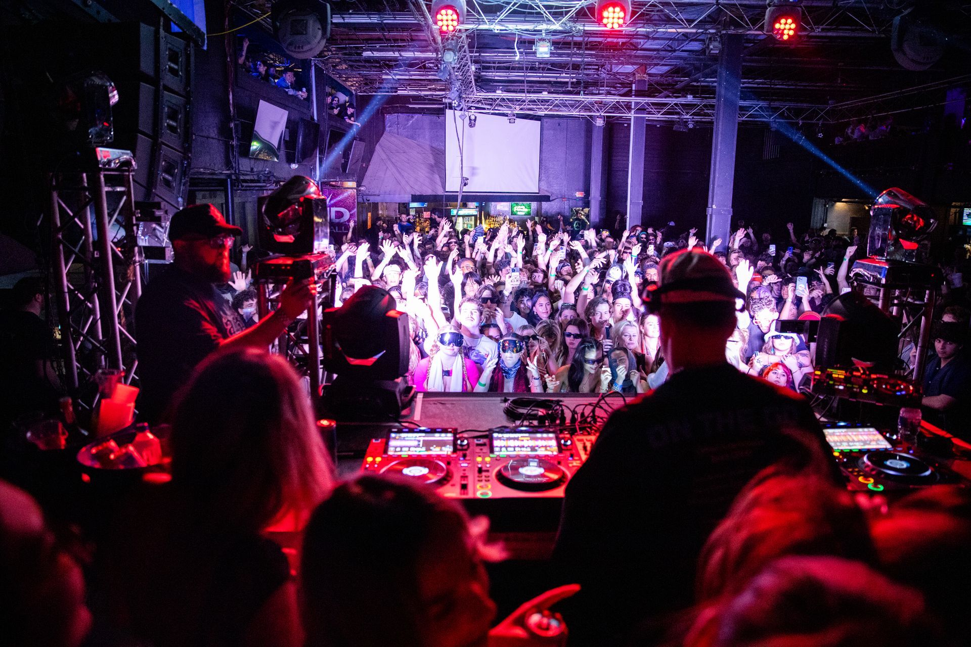 A dj is playing music in front of a crowd at a party.
