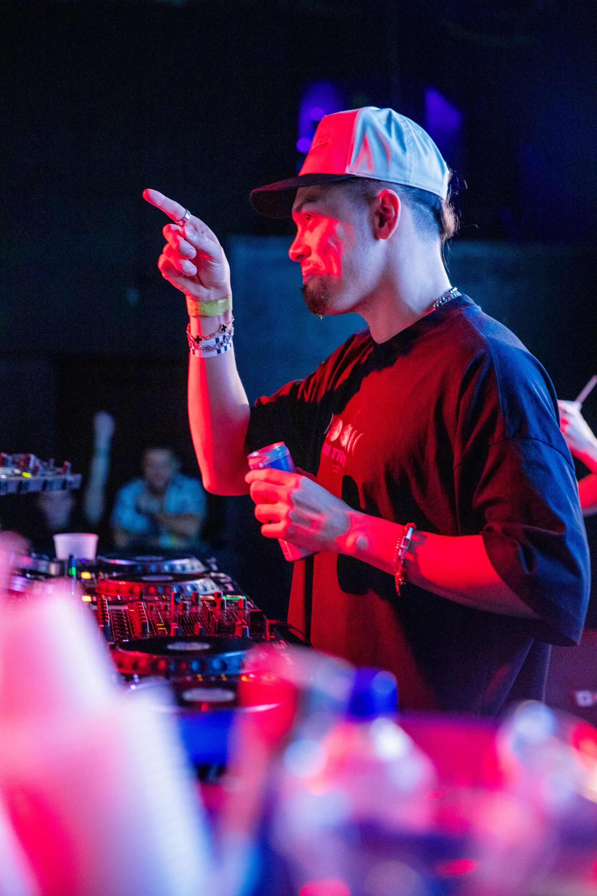 A man in a hat is pointing at something in a dark room.