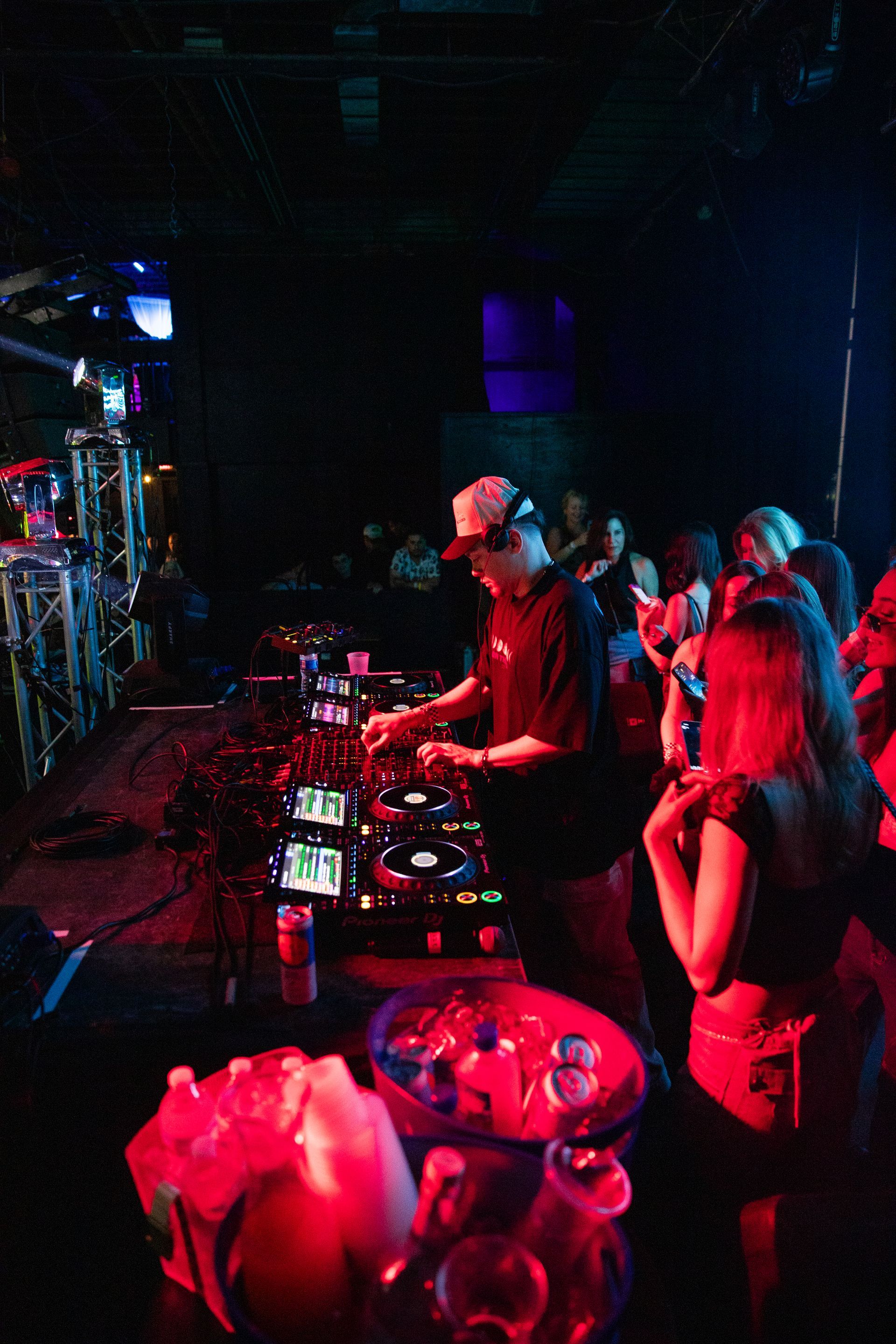 A man is playing a dj set in a dark room
