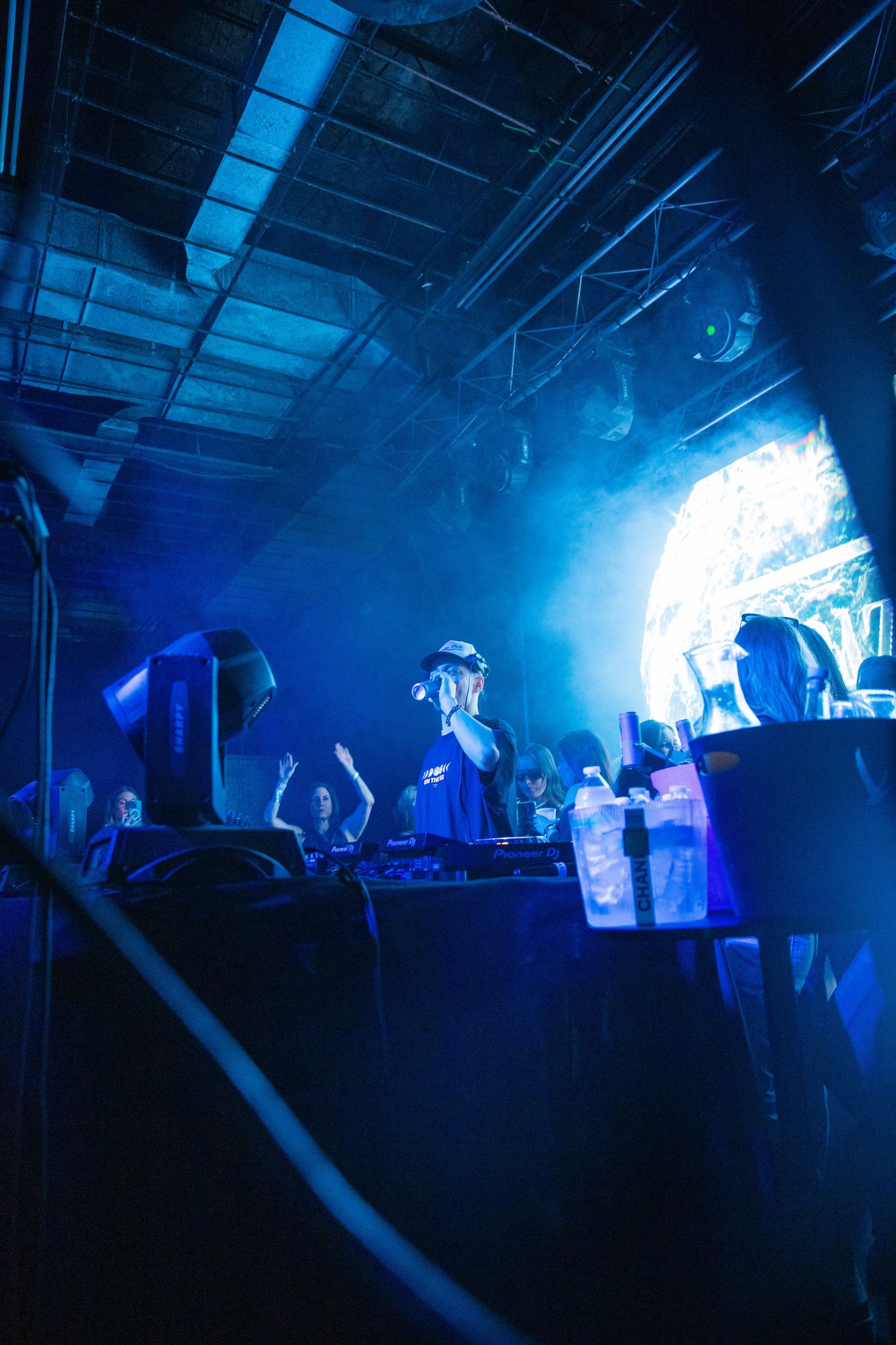 A man is singing into a microphone on a stage in front of a crowd.