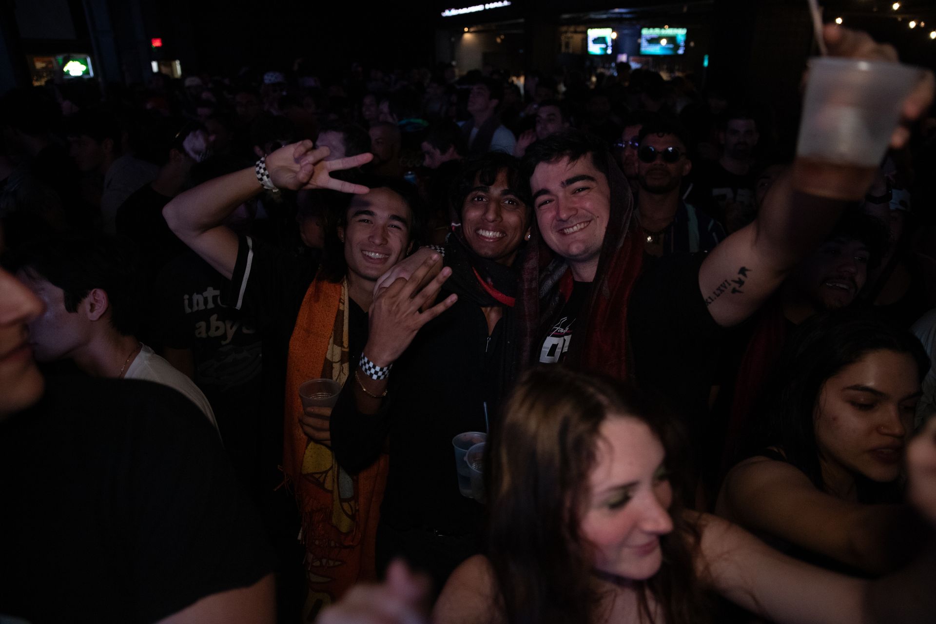 A crowd of people are dancing in a dark room