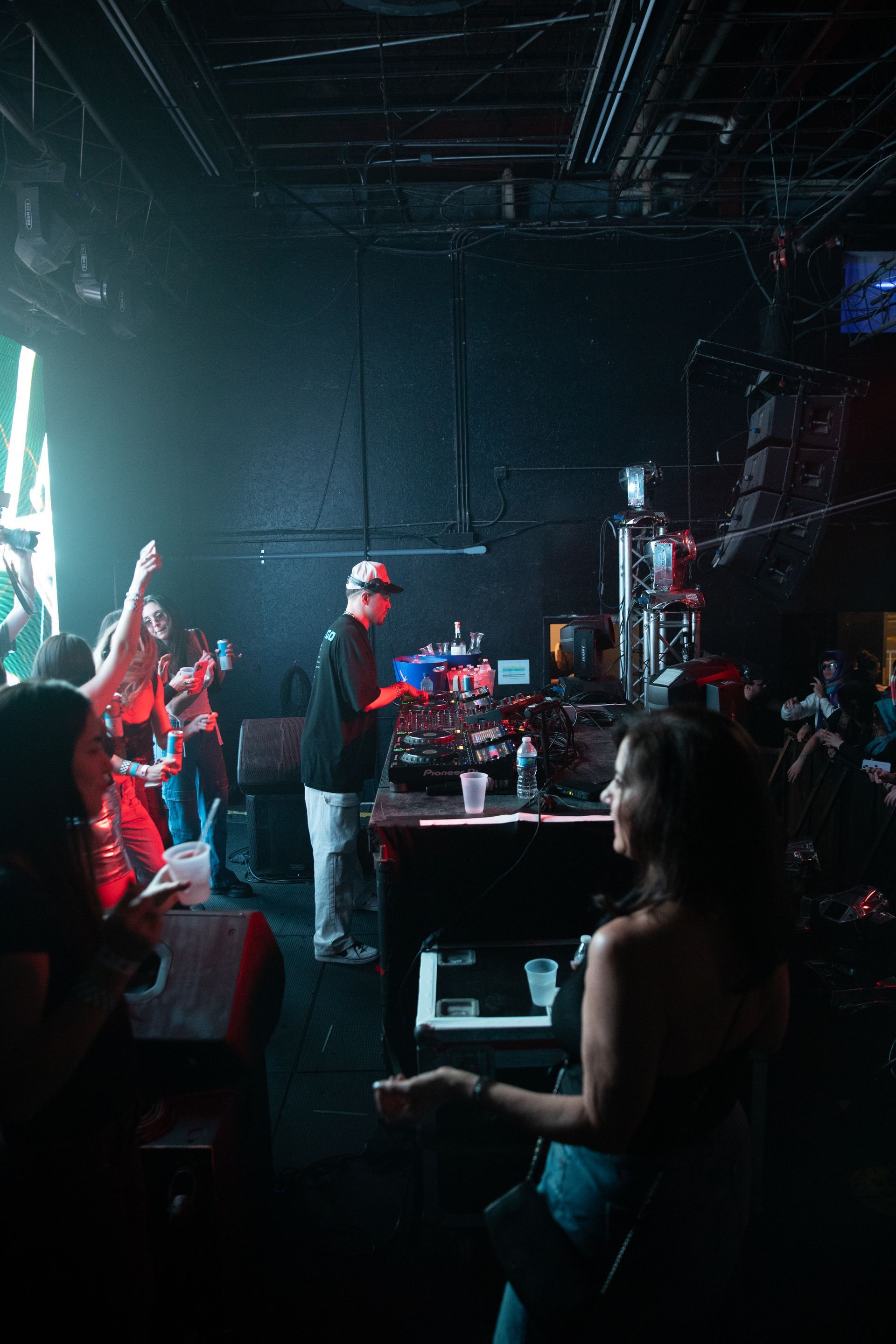 A group of people are standing in a dark room at a concert.