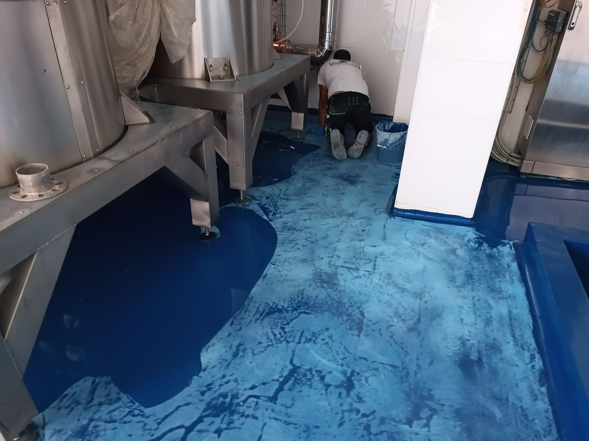 Un uomo è inginocchiato su un pavimento blu in una stanza