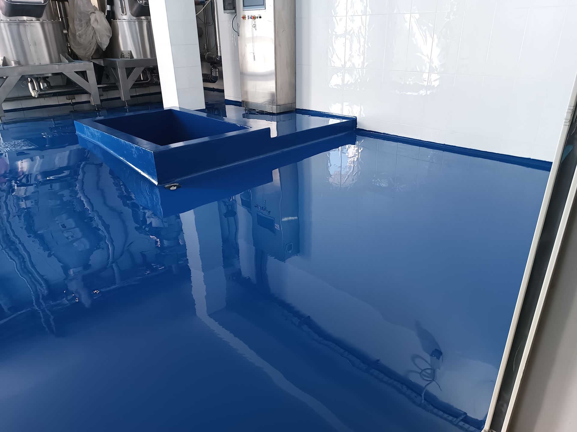 Una stanza con il pavimento blu e una parete bianca