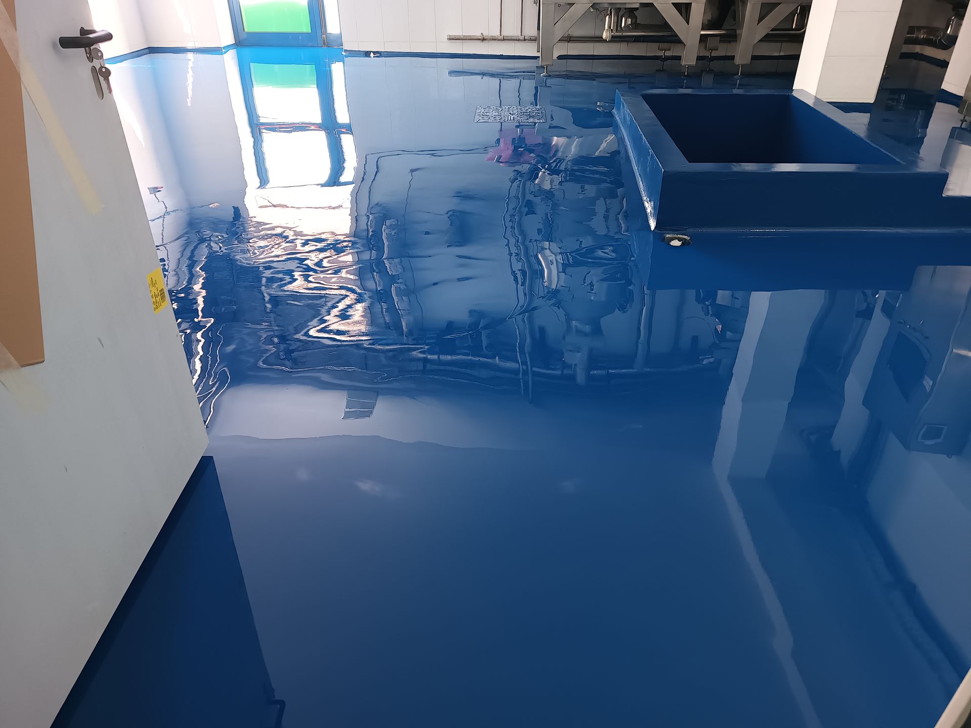 Una stanza con il pavimento blu e una parete bianca