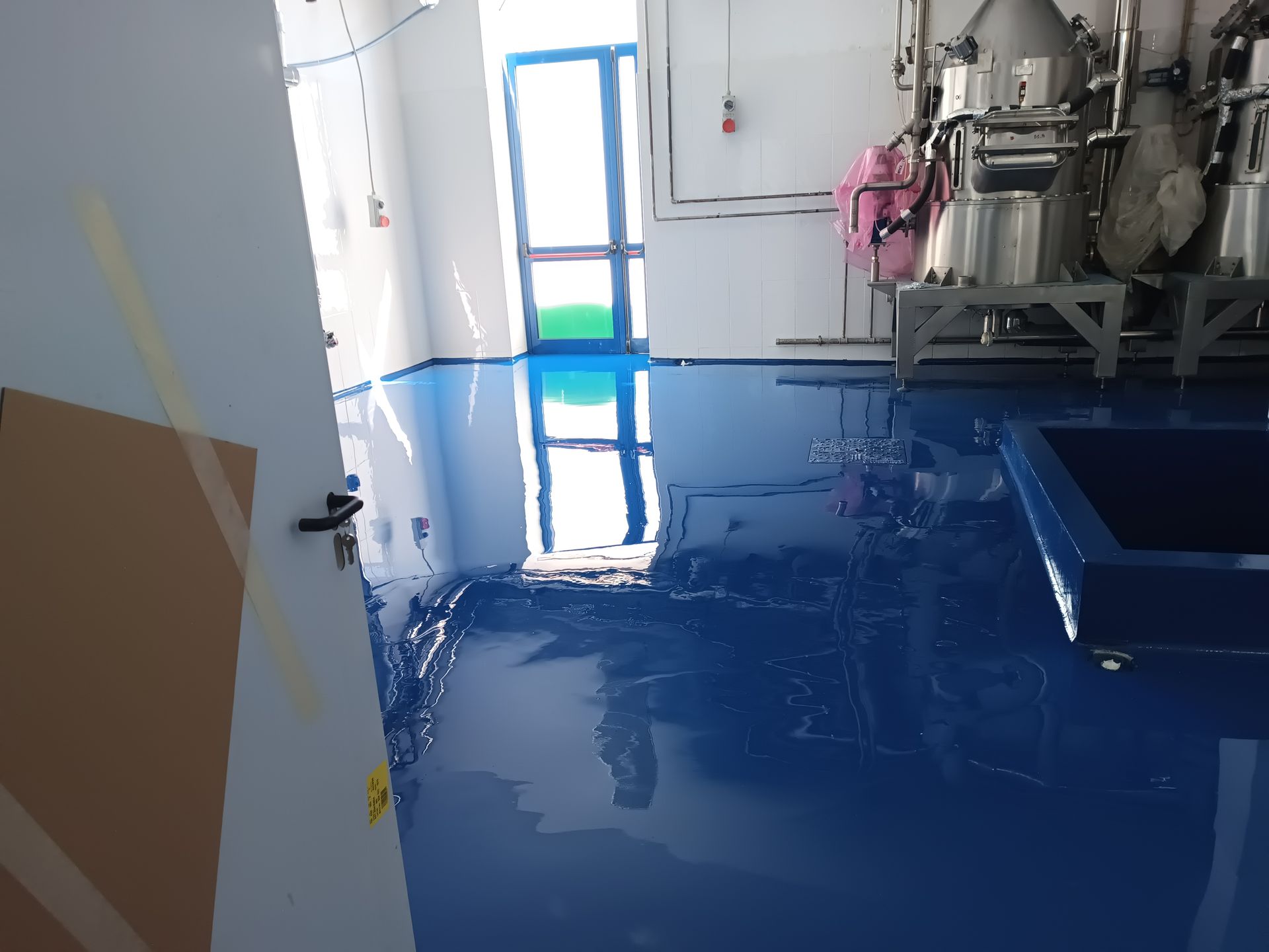 Una stanza con il pavimento blu e le pareti bianche