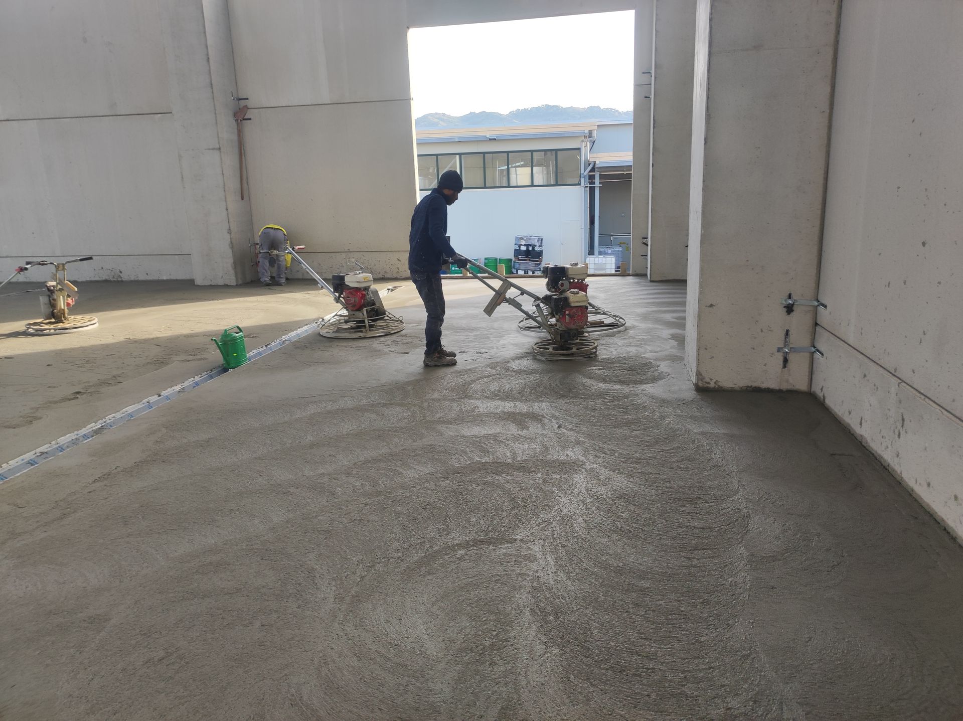 Un uomo sta lavorando su un pavimento di cemento in un magazzino