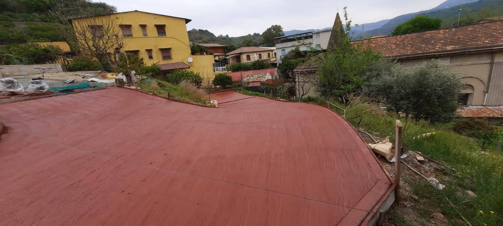 Una strada rossa con un edificio giallo sullo sfondo