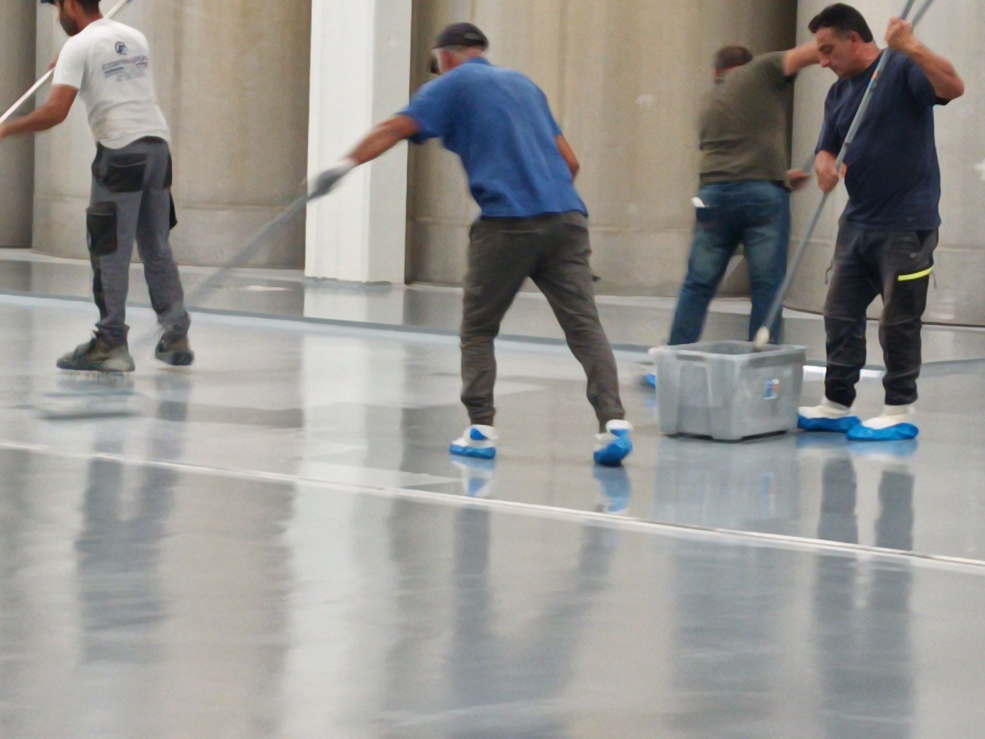 Un gruppo di uomini sta pulendo un pavimento di cemento