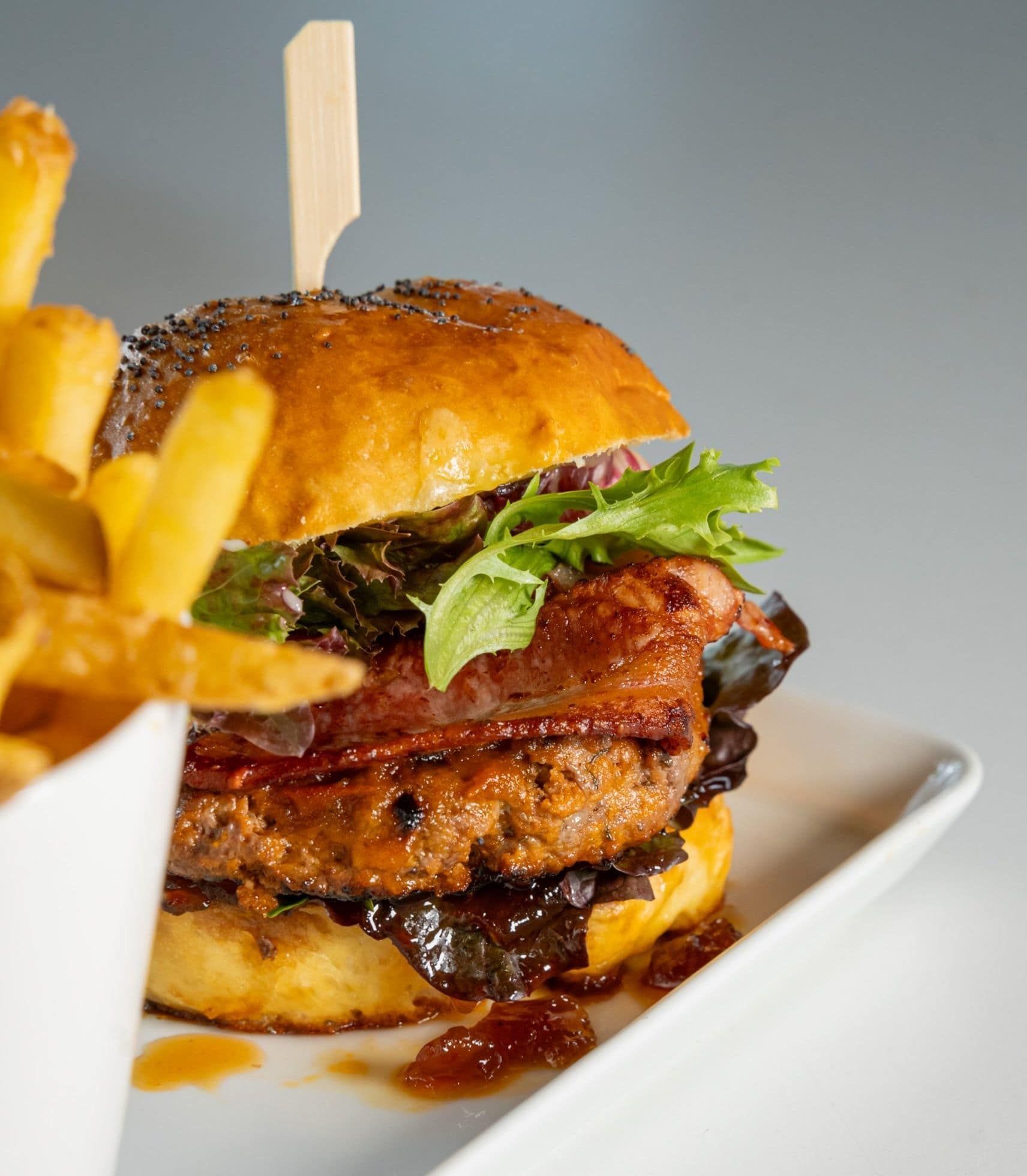 A Close Up of a Hamburger and French Fries on a Plate — My Rainbow Bakery, Cafe & Catering in Cannonvale, QLD