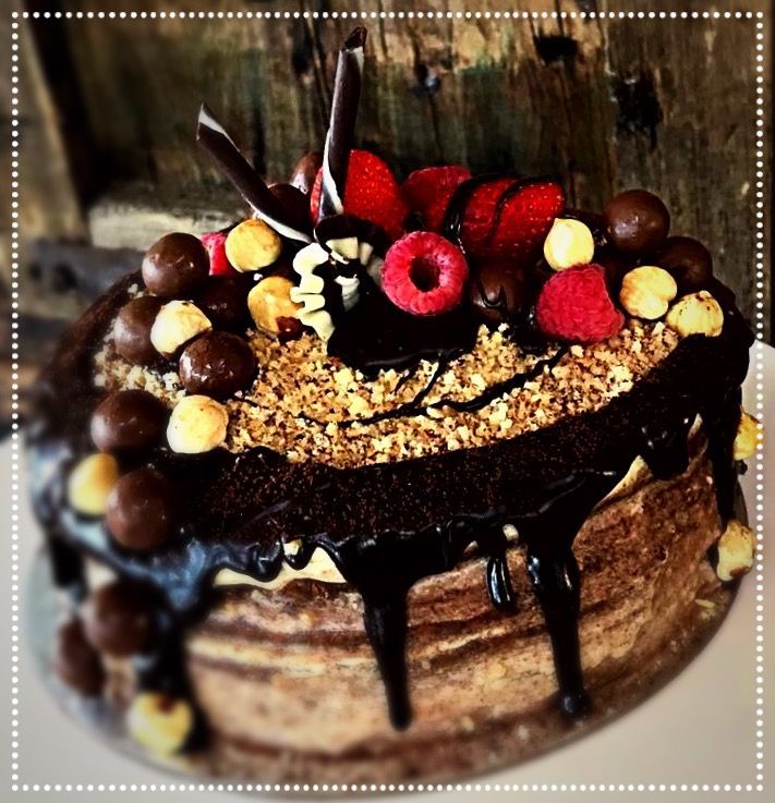 A chocolate cake with nuts and raspberries on top — My Rainbow Bakery, Cafe & Catering in Cannonvale, QLD