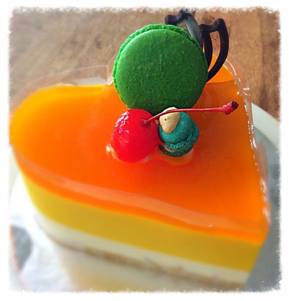 A heart shaped cake with a green macaroon and a cherry on top — My Rainbow Bakery, Cafe & Catering in Cannonvale, QLD