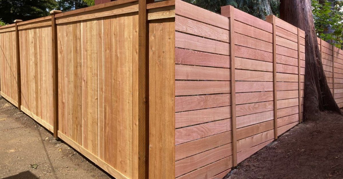 Wooden privacy fence in warm brown tones, vertical and horizontal planks.